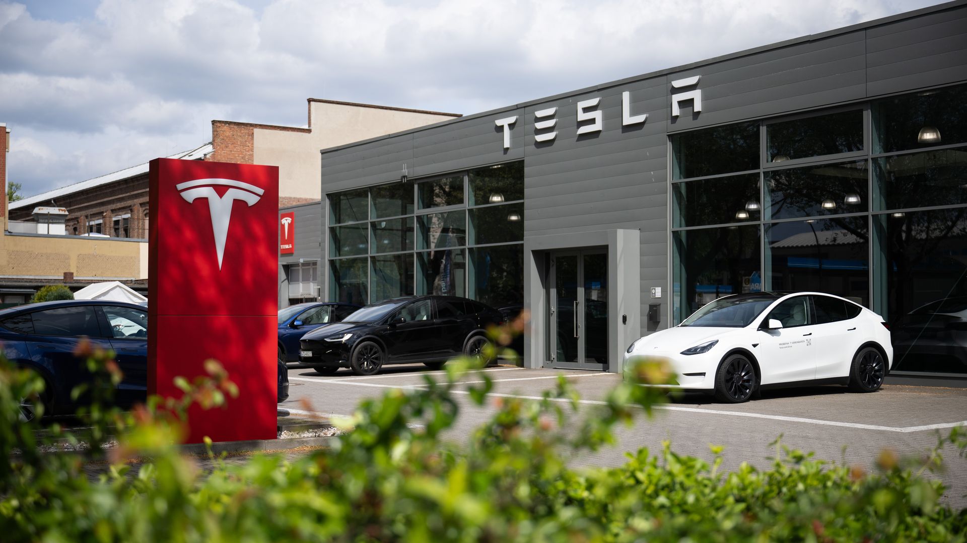 A white car in front of a Tesla service center