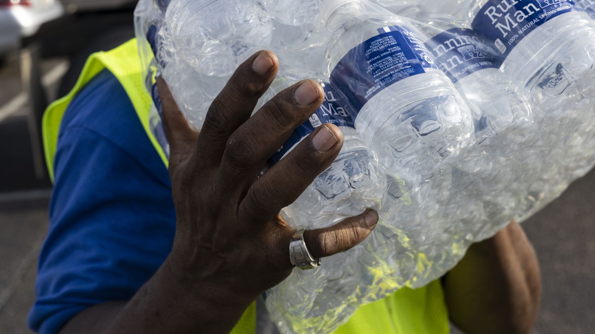 Photo of a person handling a carton of water bottles