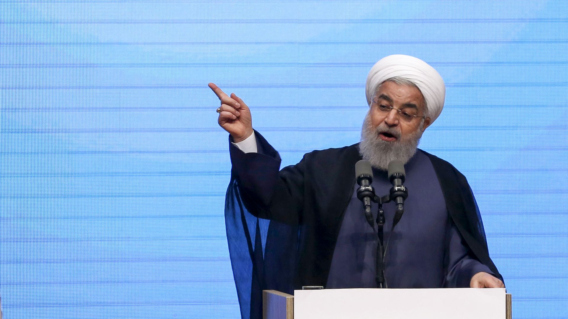 Rouhani gestures and speaks from behind a podium