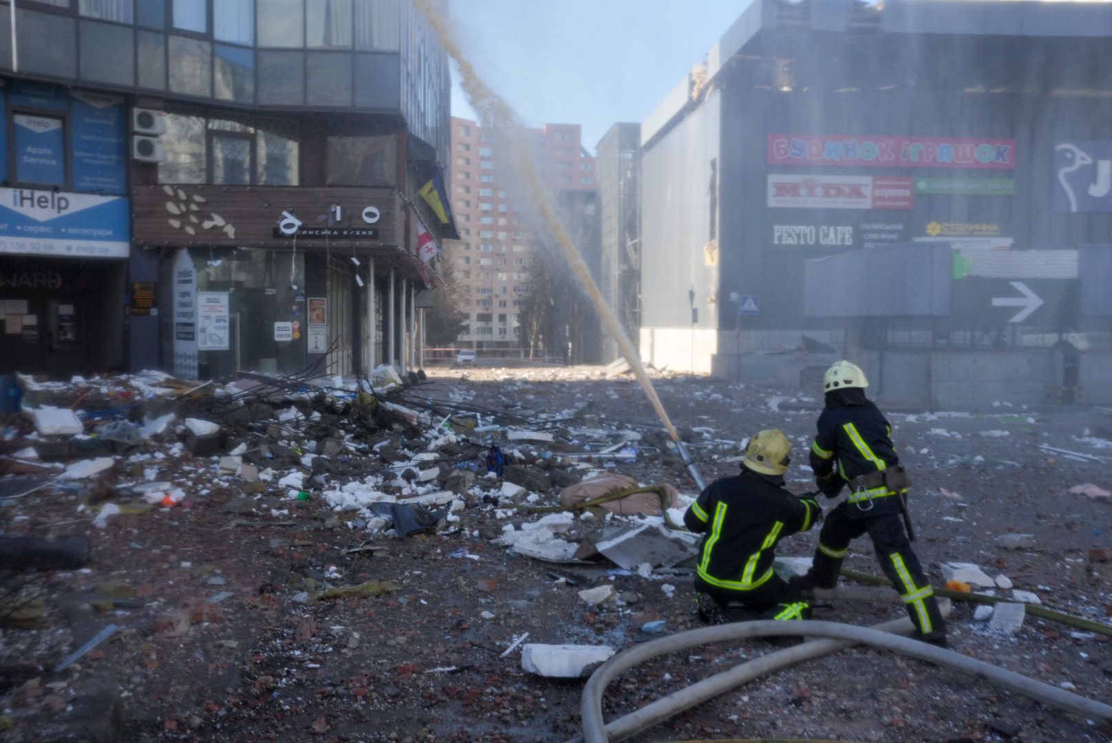Firefighters work by a residential building hit by a missile strike in the morning in Kyiv