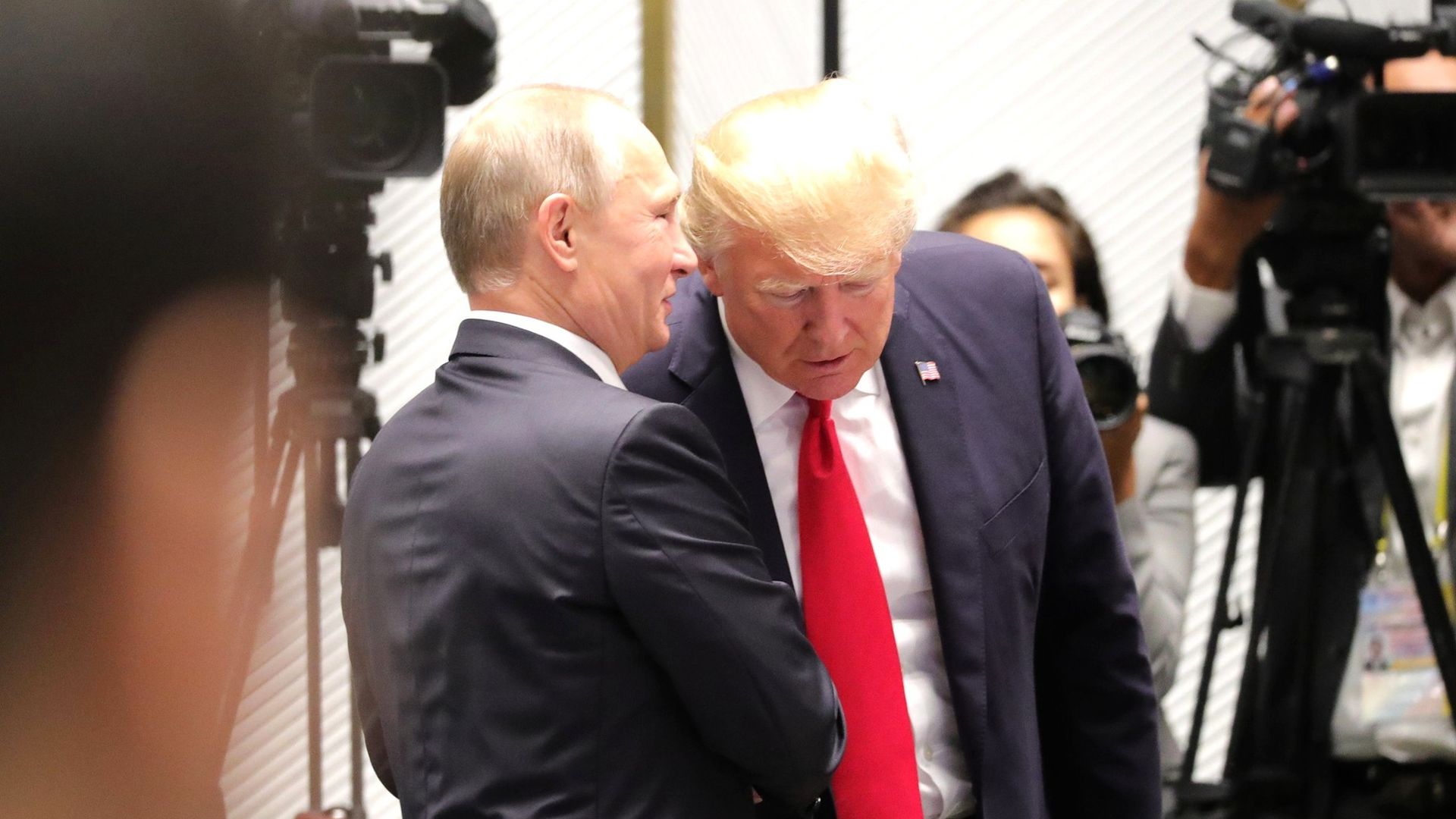 Vladimir Putin whispering into the ear of Donald Trump