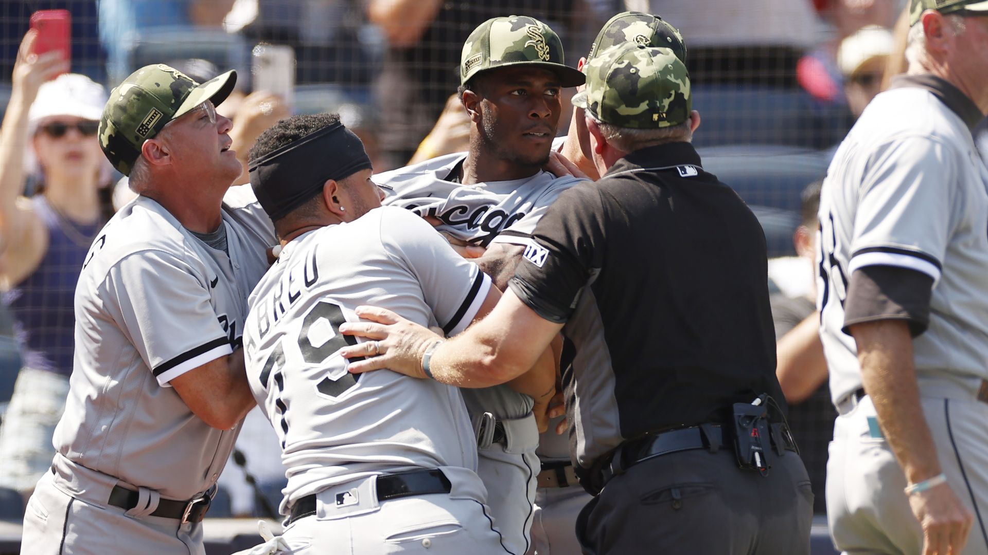 Photo of a baseball player being restrained from fighting. 