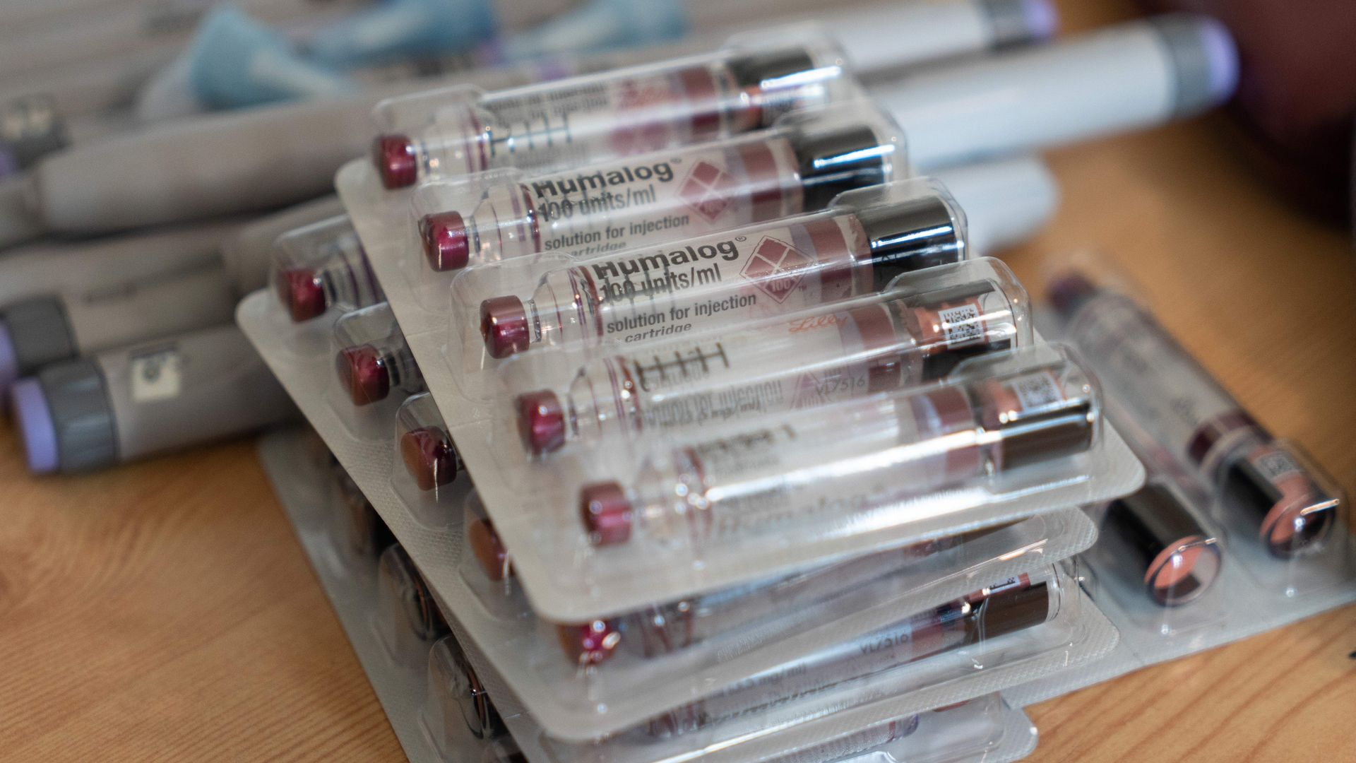 Packages of insulin vials and pens on a table.