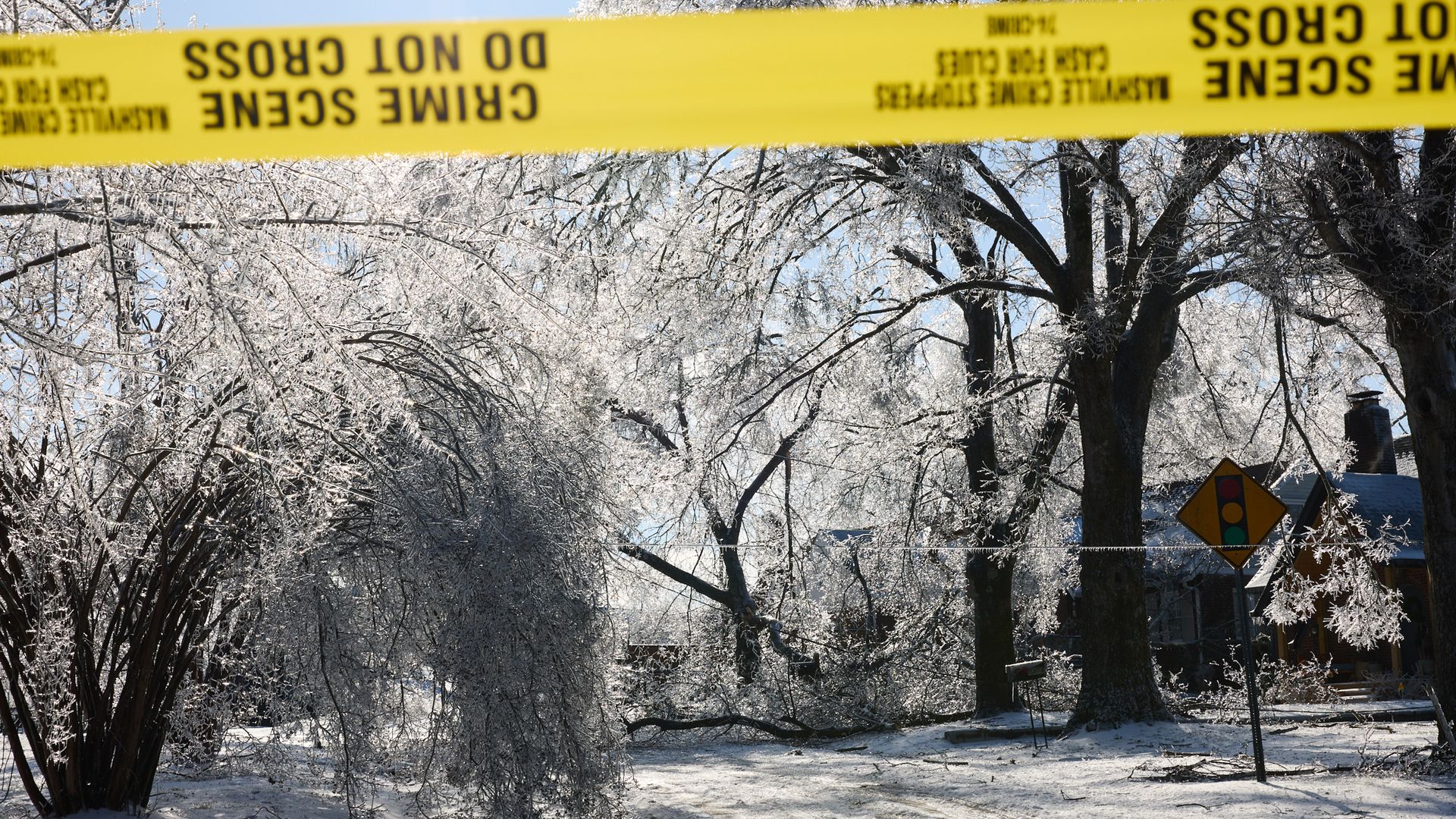 Damaged ice-covered trees and downed power lines block a road during a winter storm in east Nashville, Tennessee