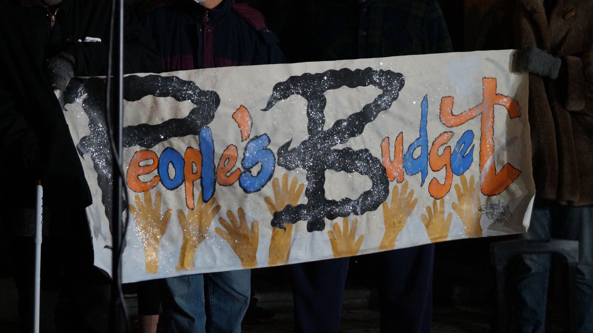 A painted banner reading "People's Budget"