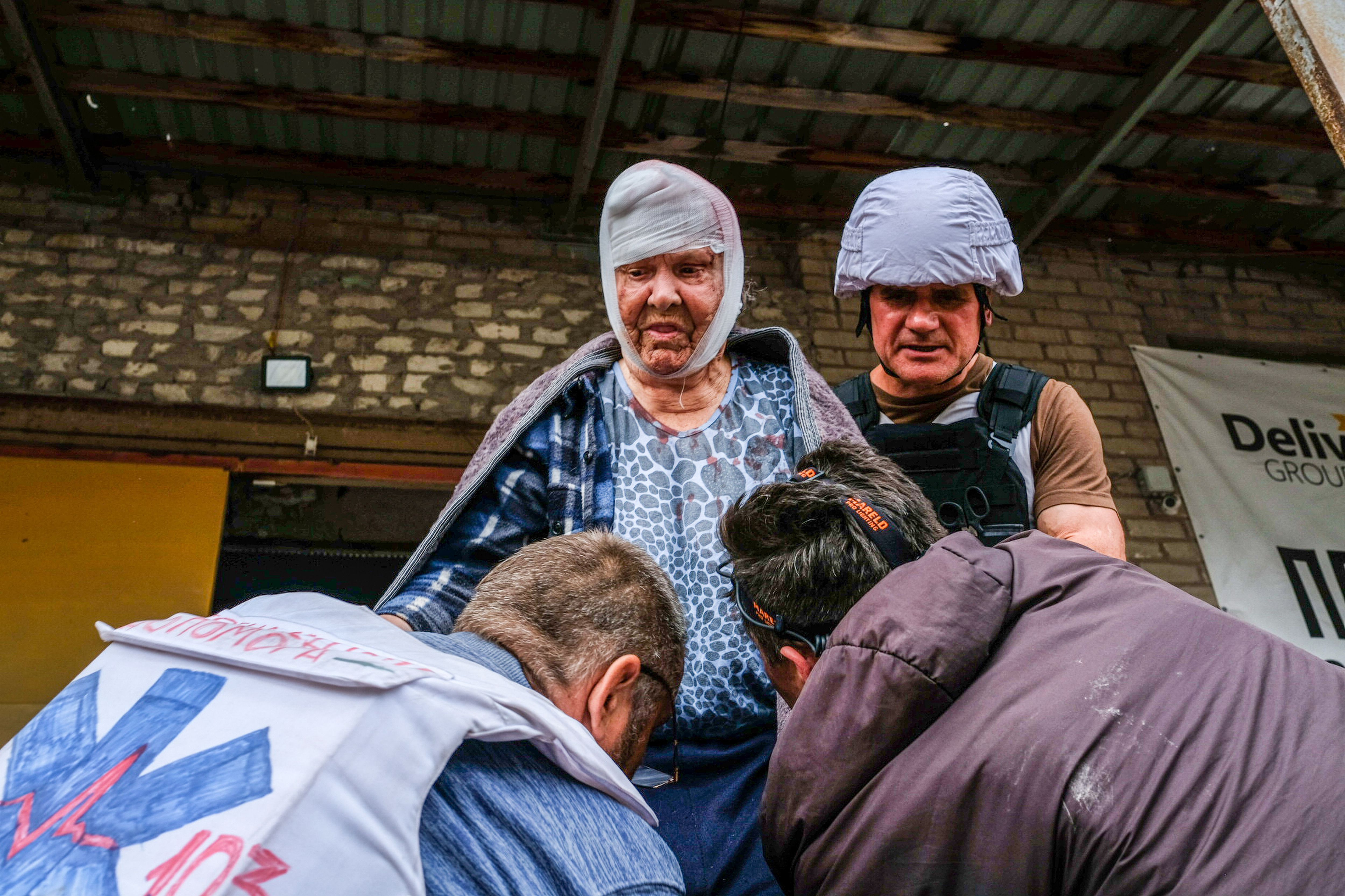 Volunteers carry an old woman injured by the Russian shelling in Severodonetsk.