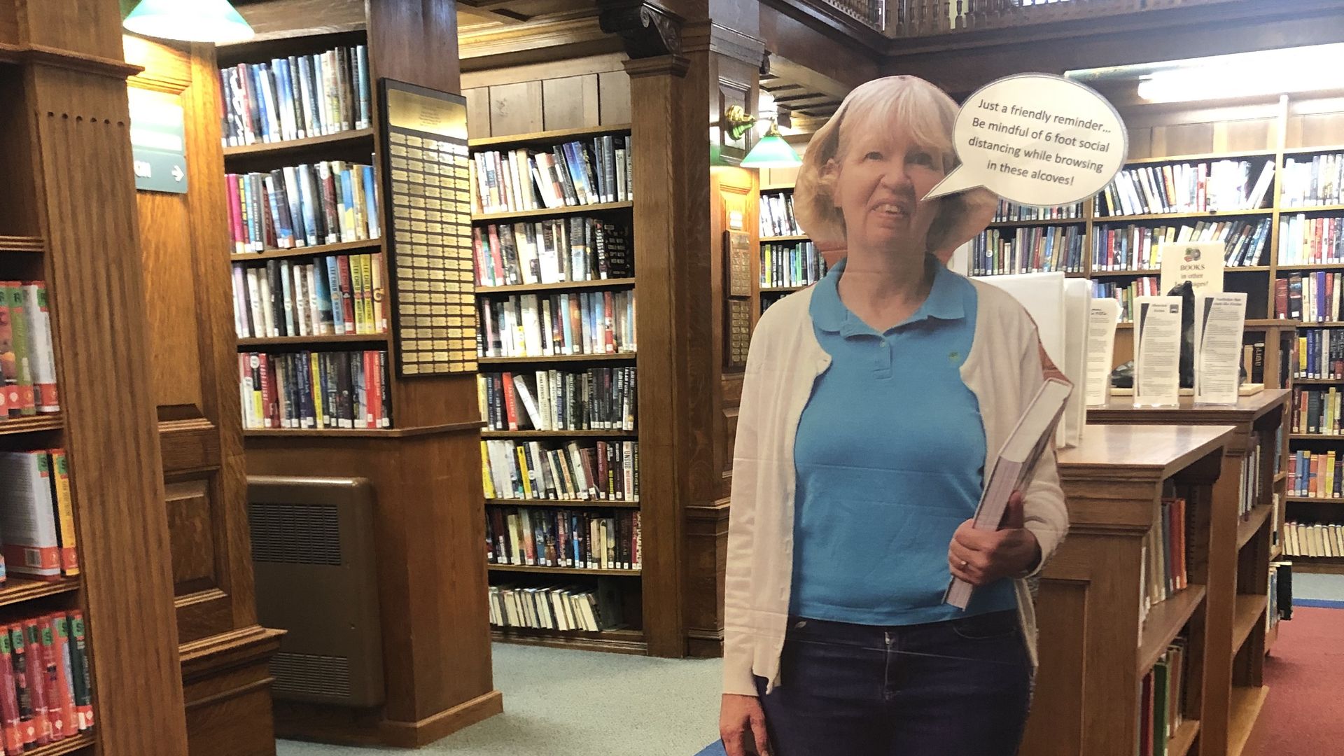 A cardboard cutout of a librarian at a Cape Cod library, reminding people to social distance