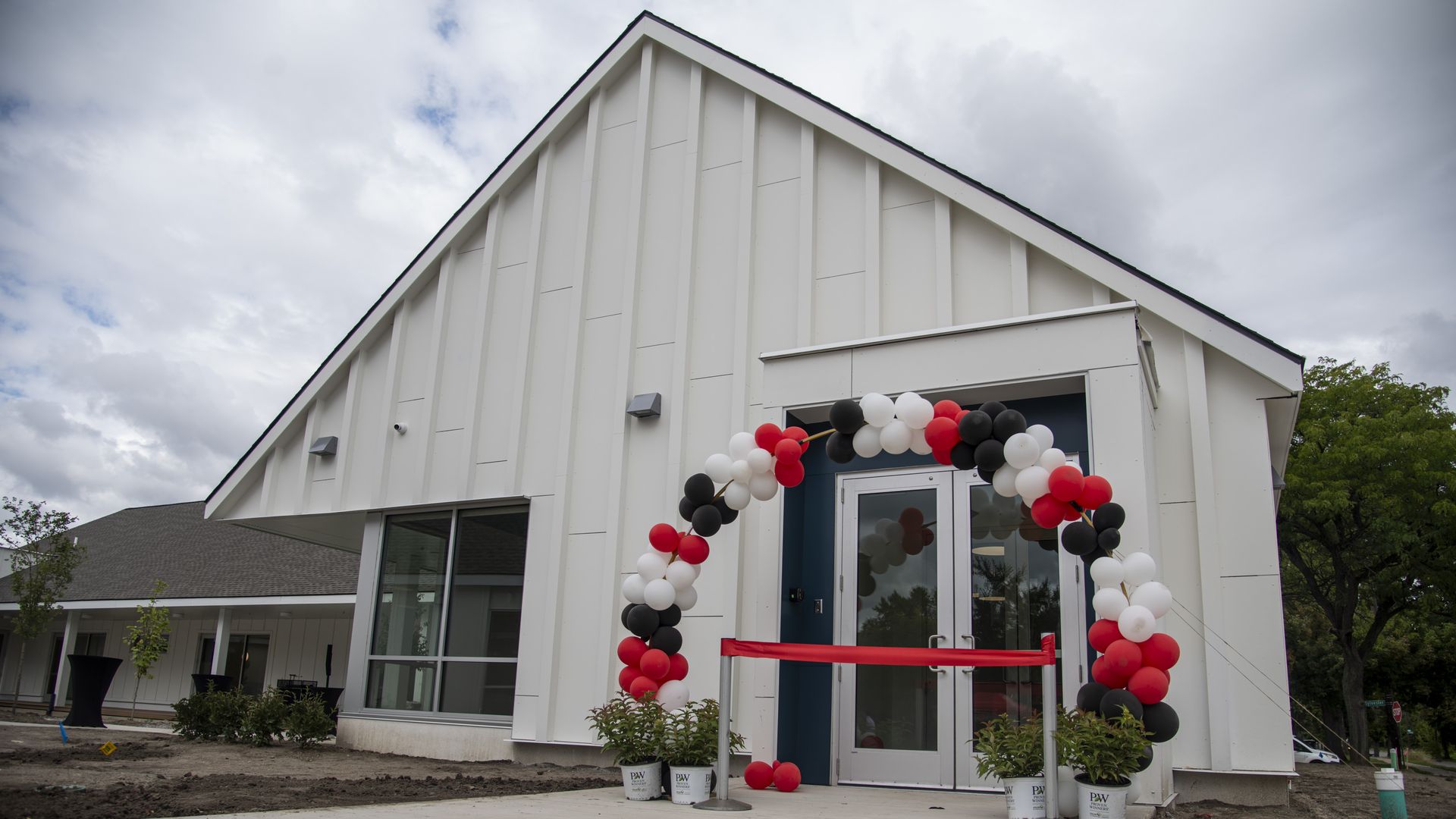 The white facade of the student learning center with a balloon arch to celebrate the opening.