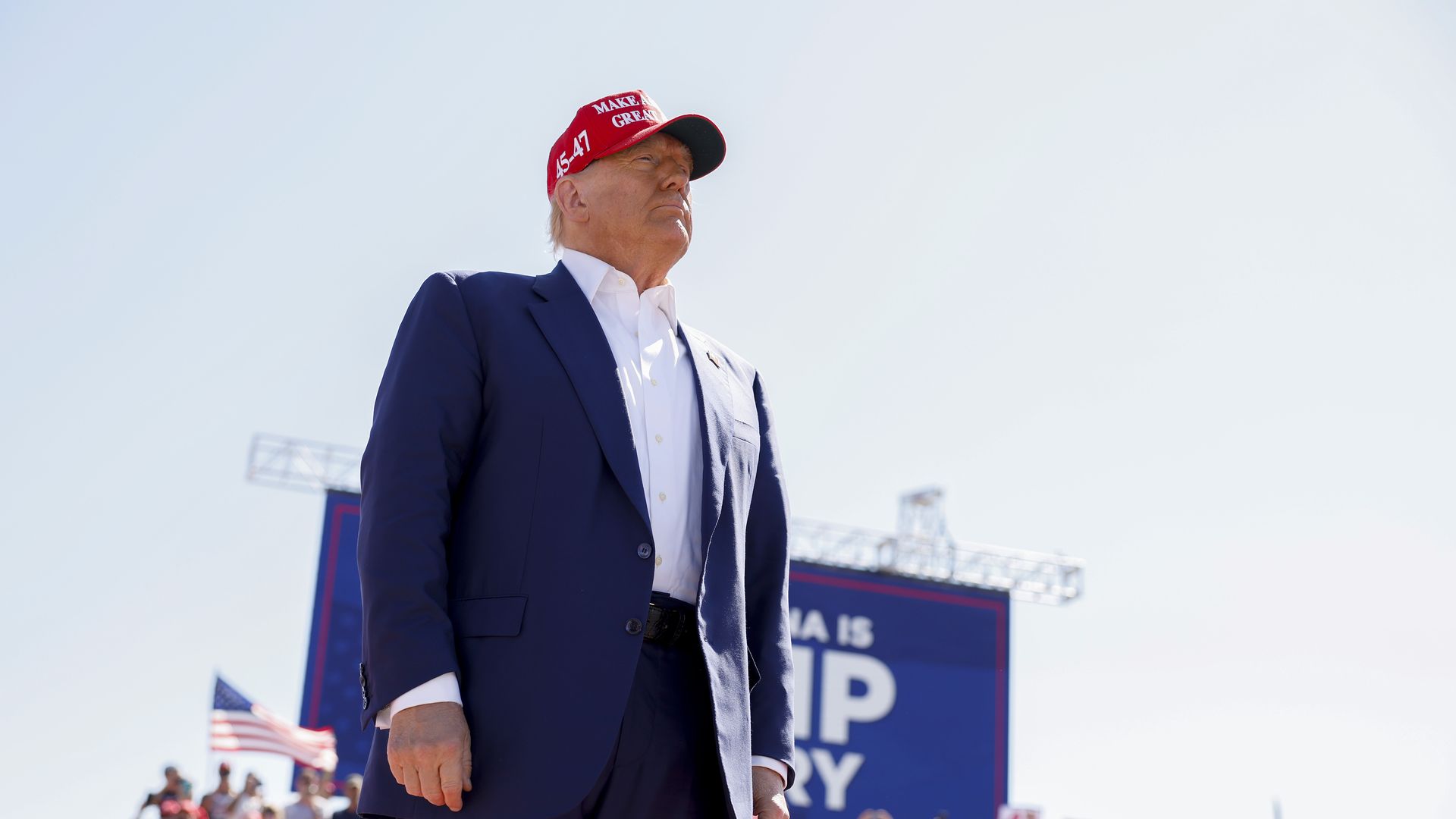 Trump stands in front of an audience at a rally.