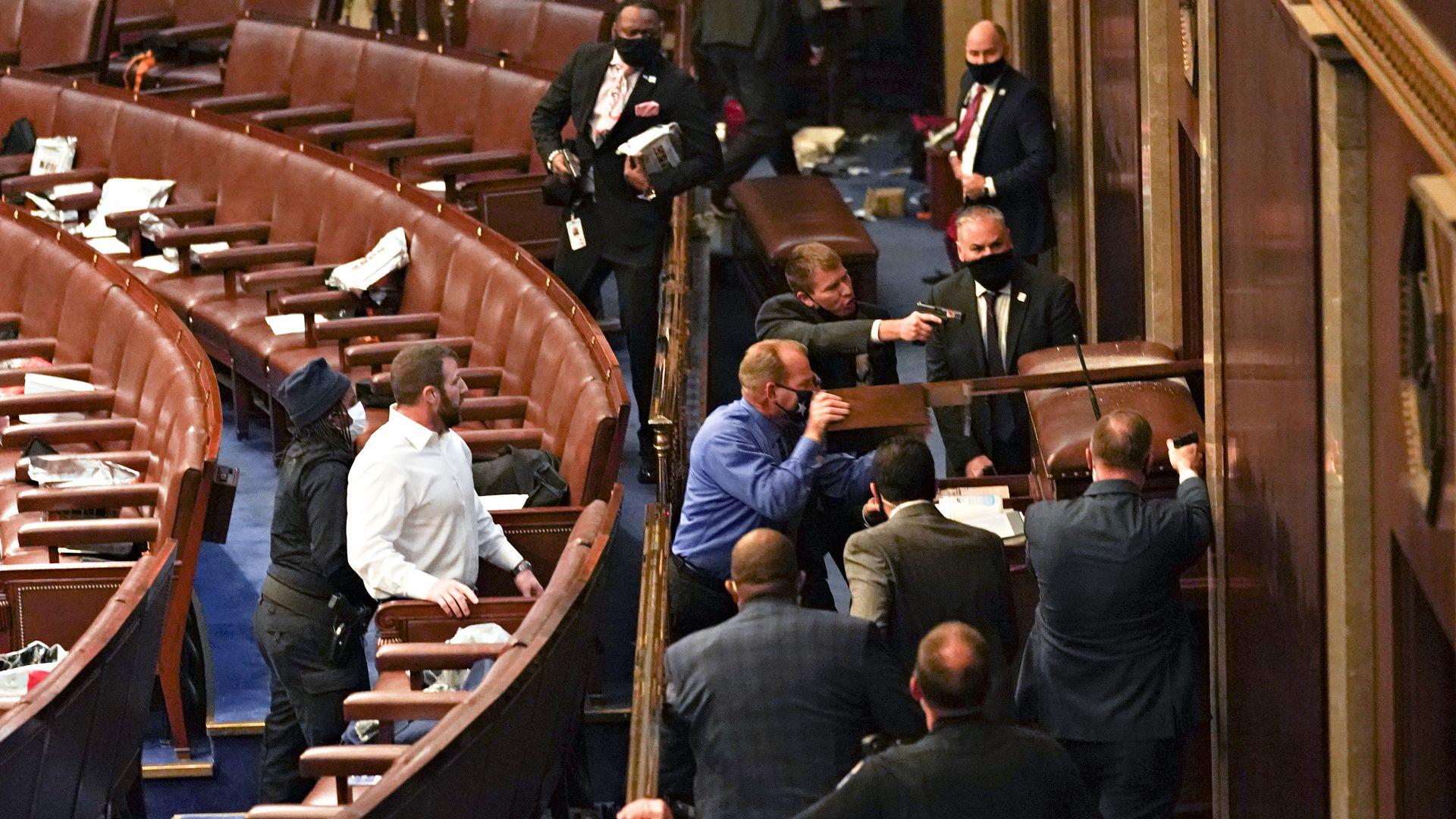 Members of the Capitol Police are seen pointing guns at the door of the House Chamber as rioters stand outside on Jan. 6, 2021.
