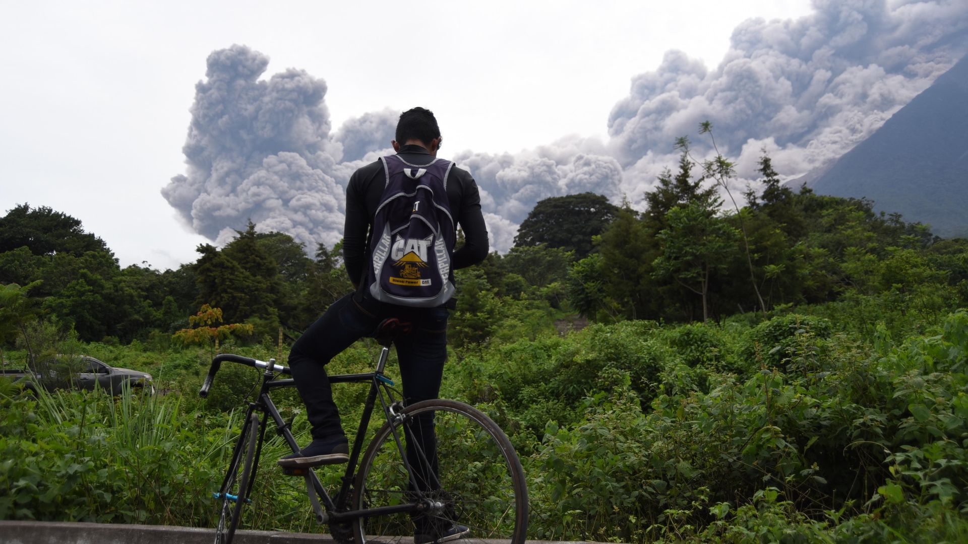 A man looking at Fuego's eruption