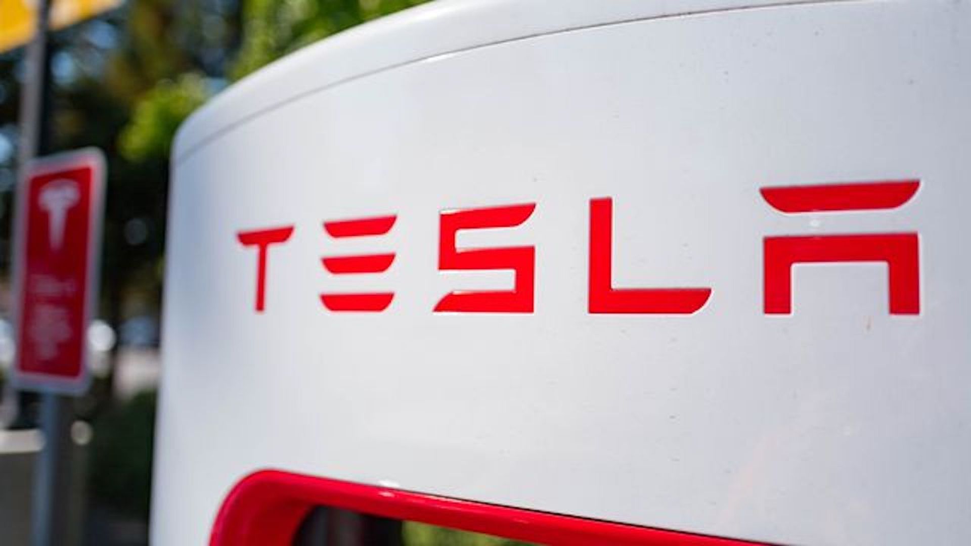 Photo of a Tesla vehicle charger with the company logo.