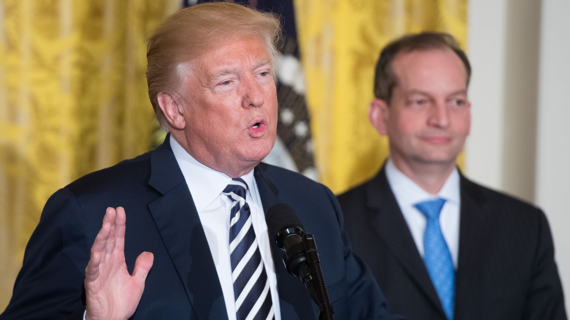 US President Donald Trump speaks alongside Secretary of Labor Alexander Acosta (R) during the National Teacher of the Year reception in the East Room of the White House in Washington, DC, May 2, 2018.