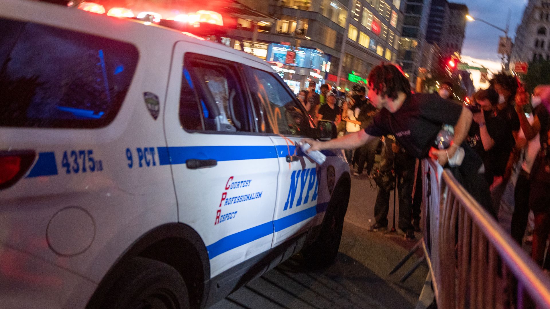 A protester tags a police car with spray paint in New York City