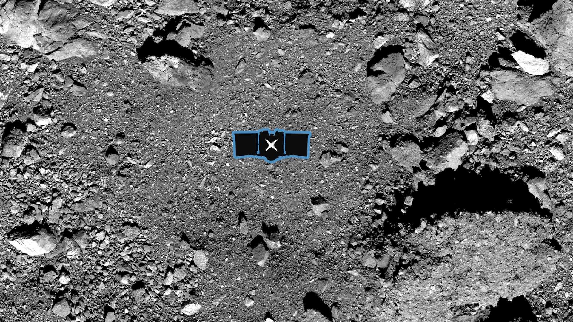 A black and white photo showing a rock-strewn landscape with a small outline of a spacecraft indicating a sample site point