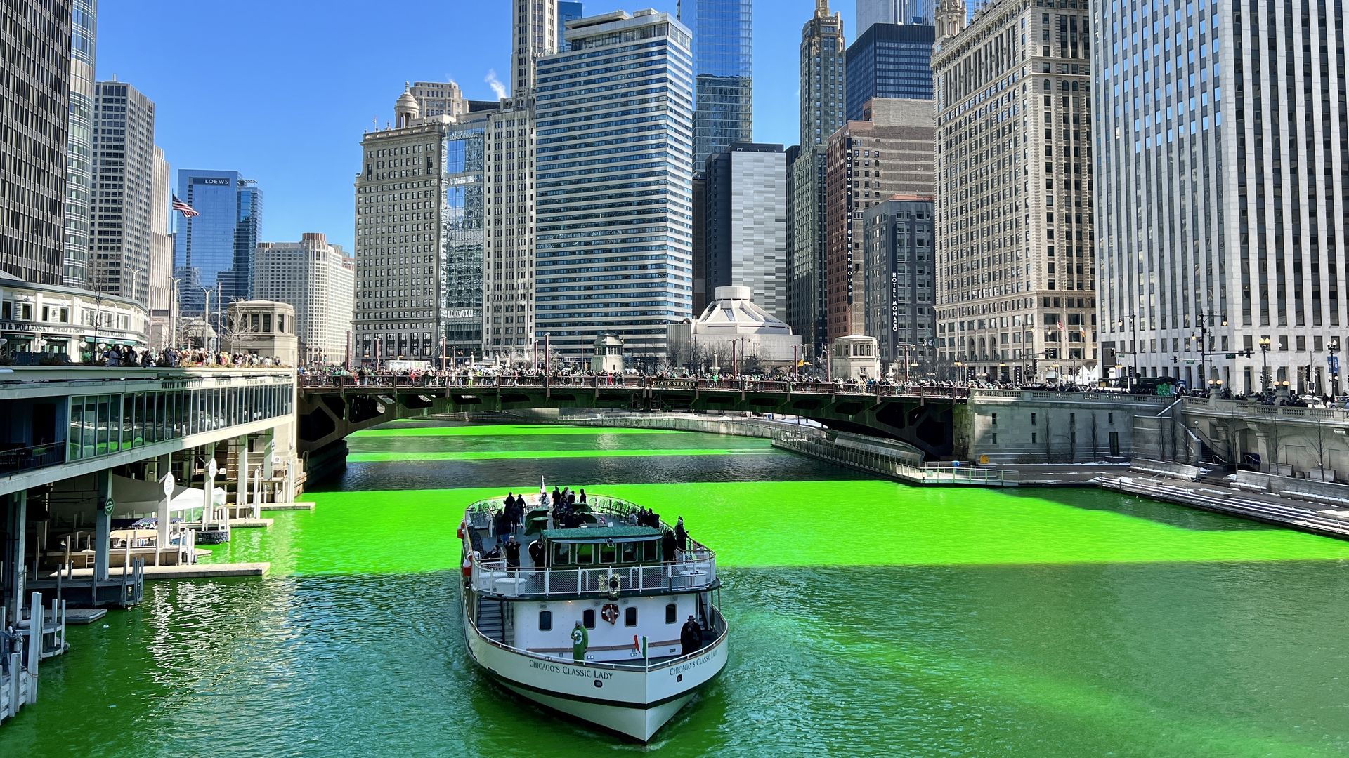 river died green and a boat passing by chicago skyscrapers