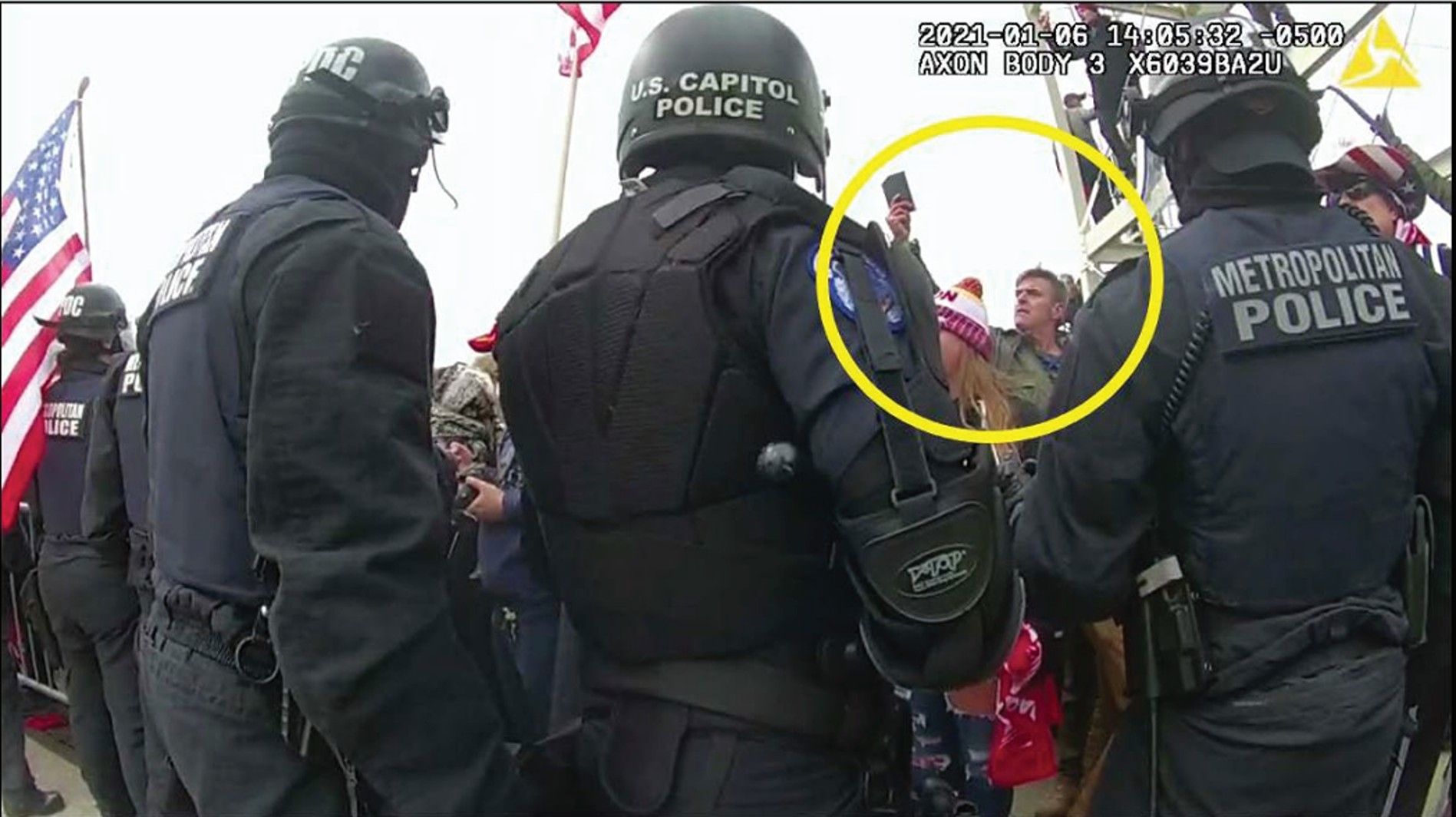 A man (circled) identified by prosecutors as Jay James Johnston wearing a green camouflage neck gaiter and a dark leather jacket. 