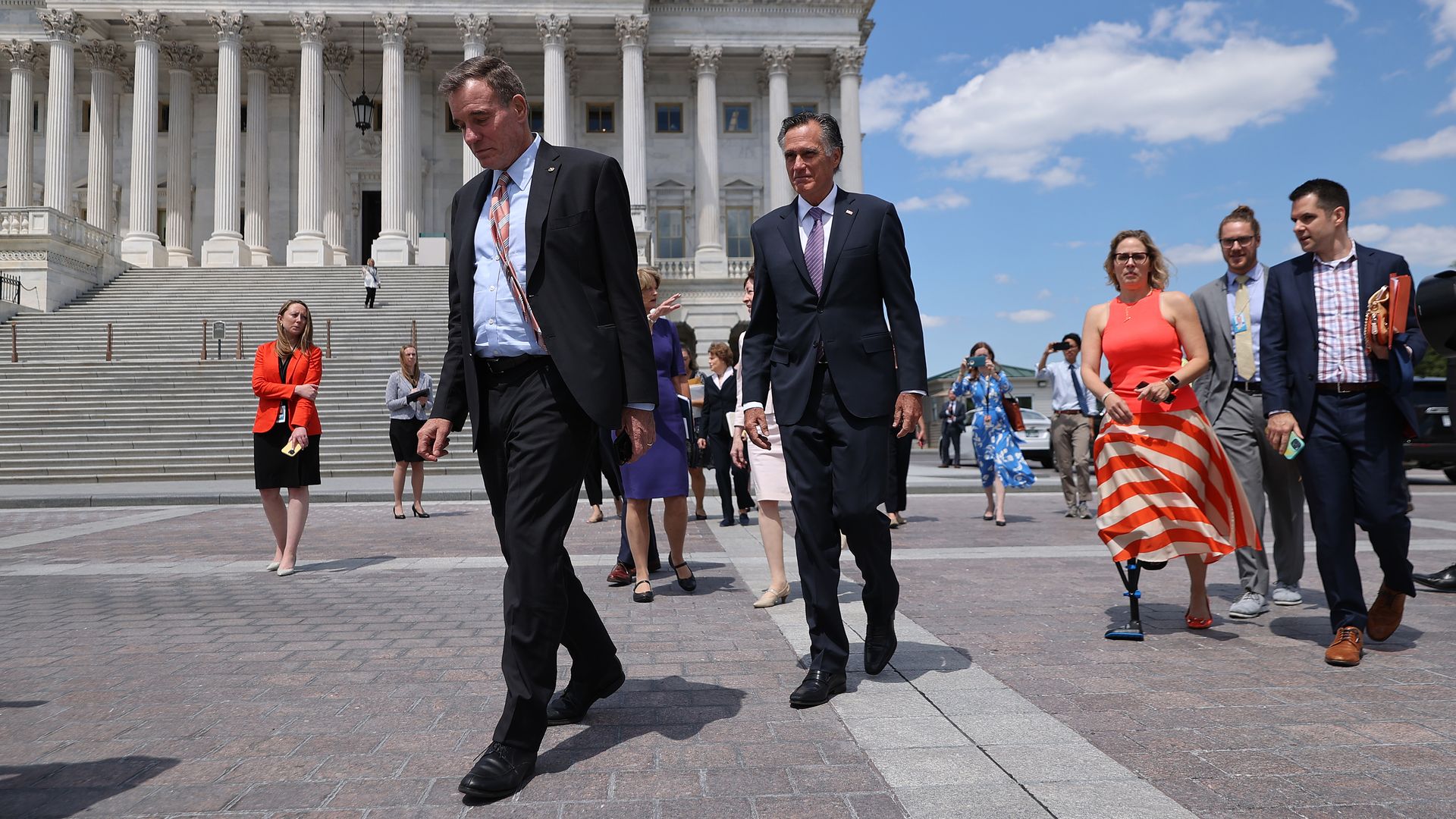 Sen. Mark Warner is seen leading Sens. Mitt Romney and Krysten Sinema to their meeting with President Biden.