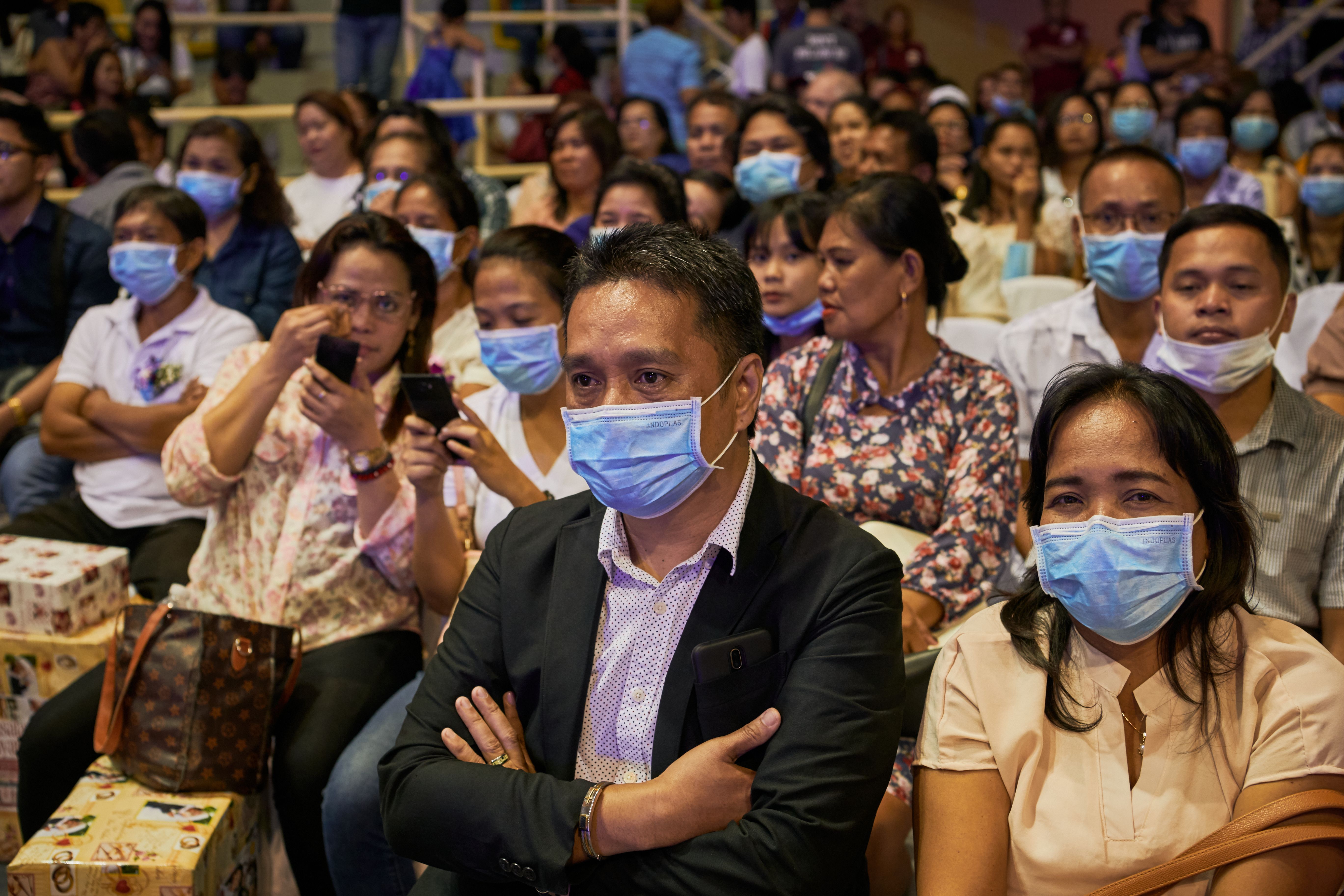 In this image, rows of people wear face masks at a wedding