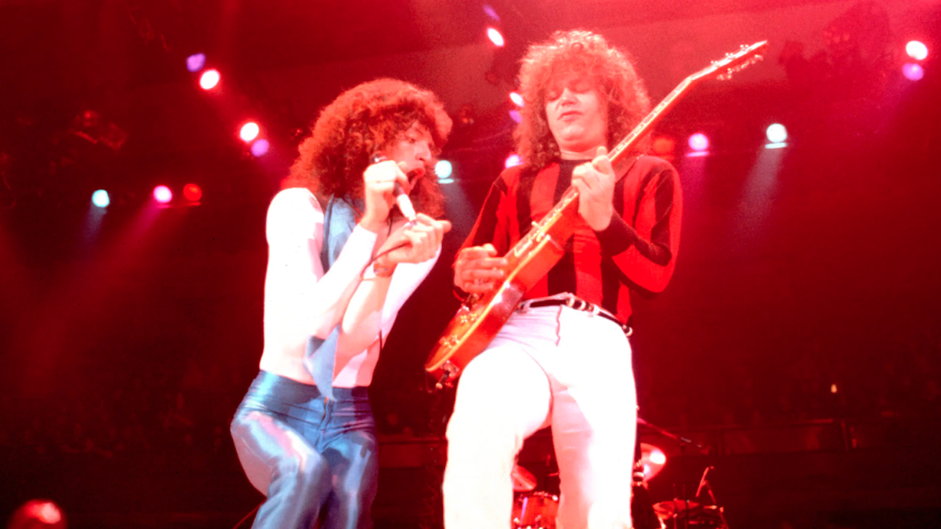 Photo of two rock stars on stage performing