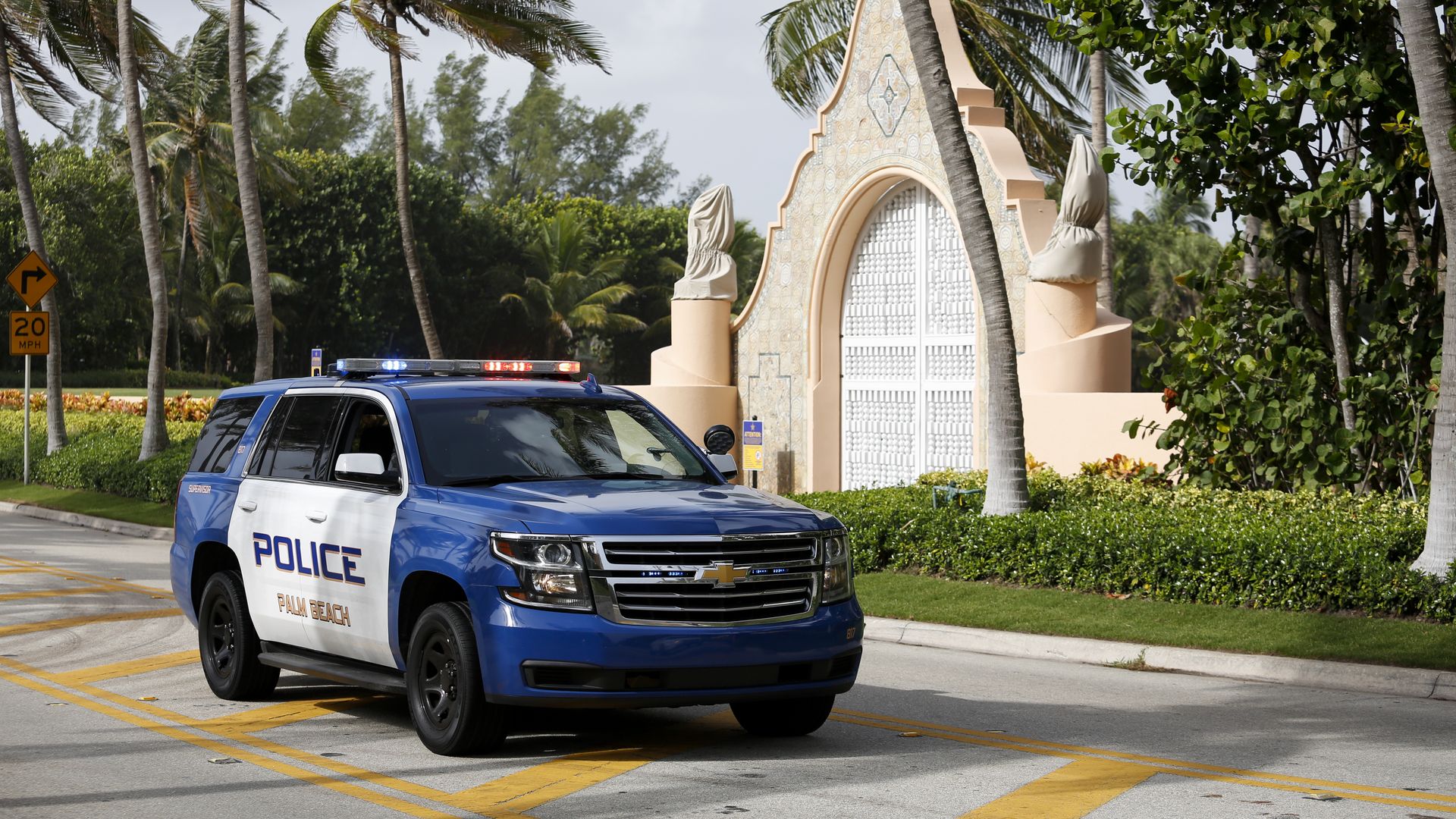 Photo of a police car parked in front of the entrance gate to Mar-a-Lago