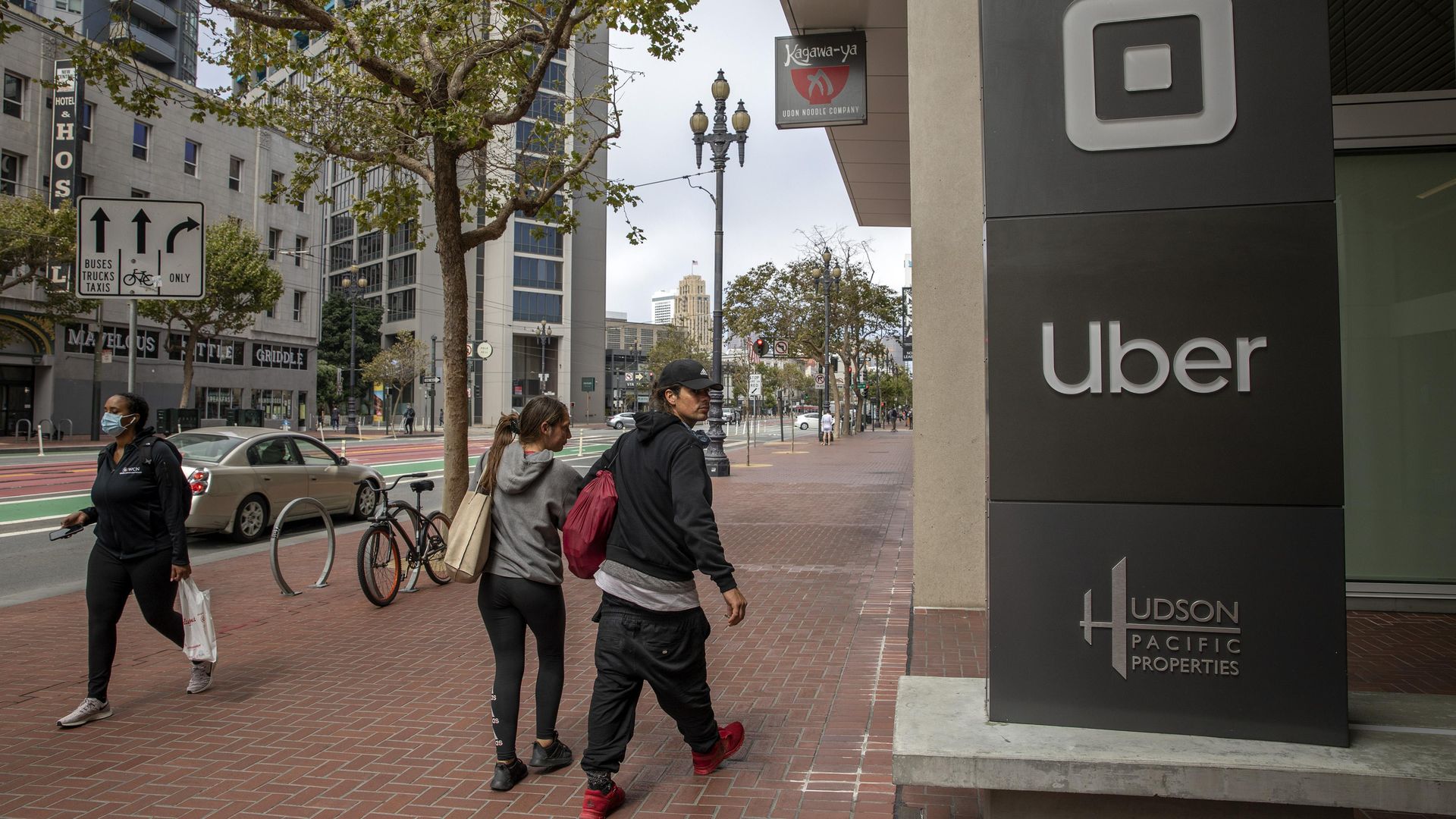 Pedestrians walk past a signage displayed outside Uber Technologies headquarters on August 10, 2020 in San Francisco, California. 