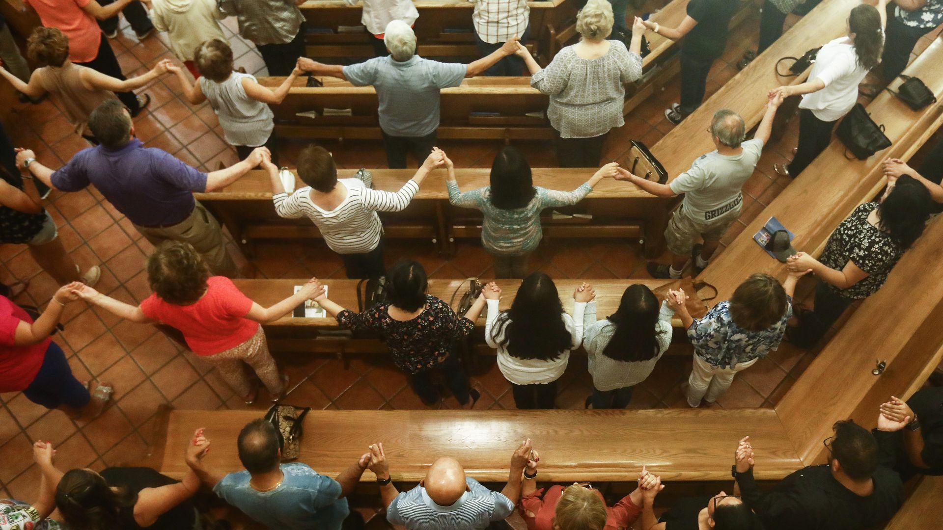 People hold hands at a vigil