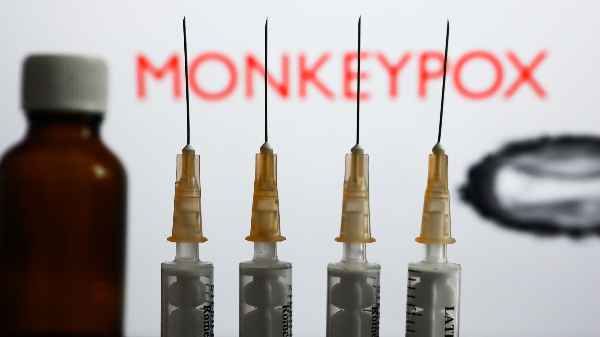 Medical syringes and a bottle are seen with 'Monkeypox' sign.