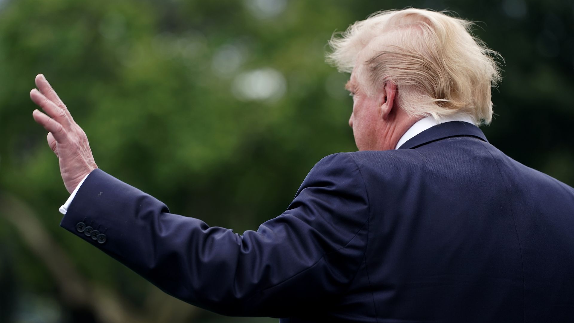 This image shows the back of Trump's head as he waves and walks away.