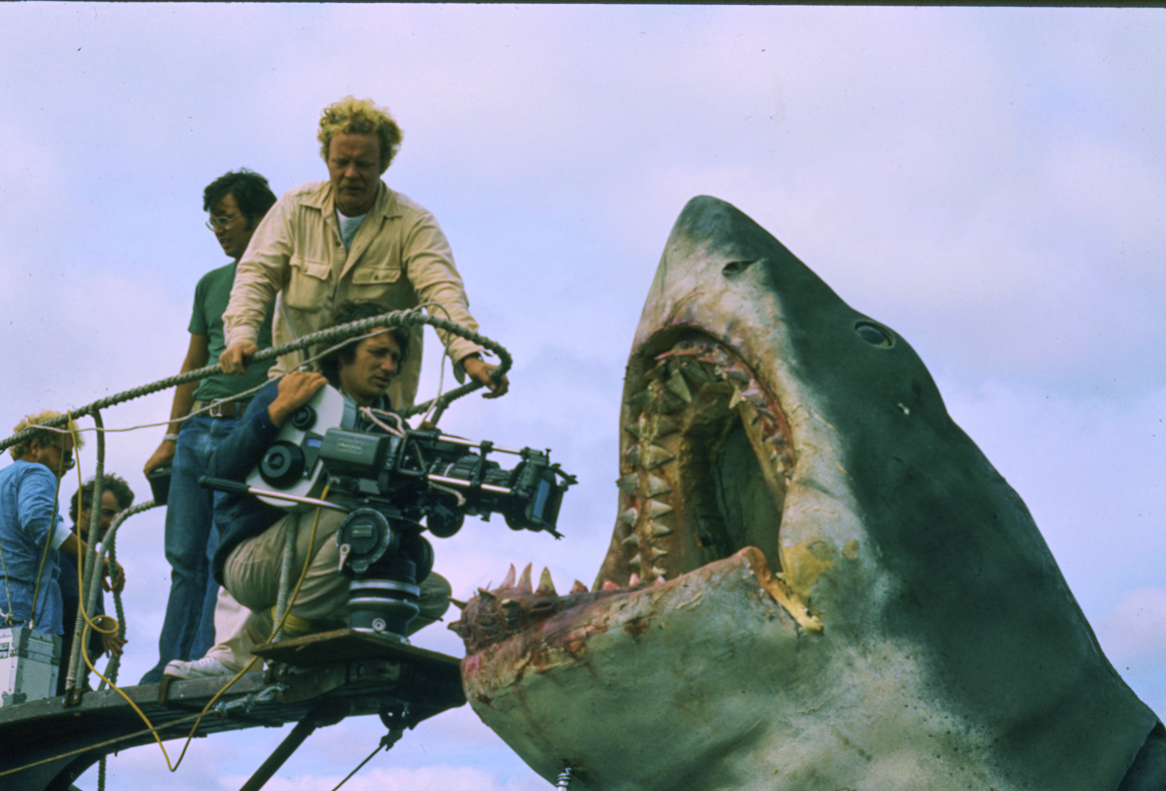 This image released by Peacock shows cinematographer Bill Butler, standing, and director Steven Spielberg during the filming of "Jaws." (Peacock/Universal Pictures via AP)