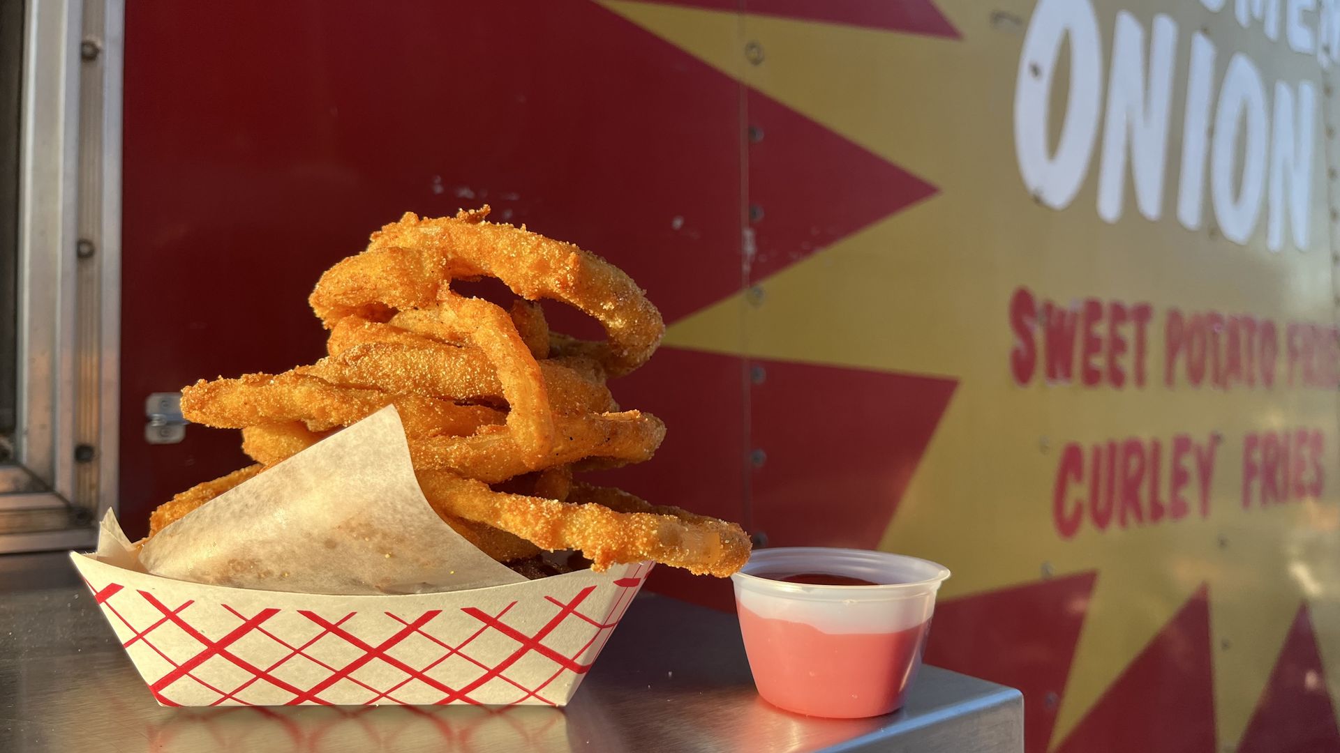 a stack of onion rings outside of food truck
