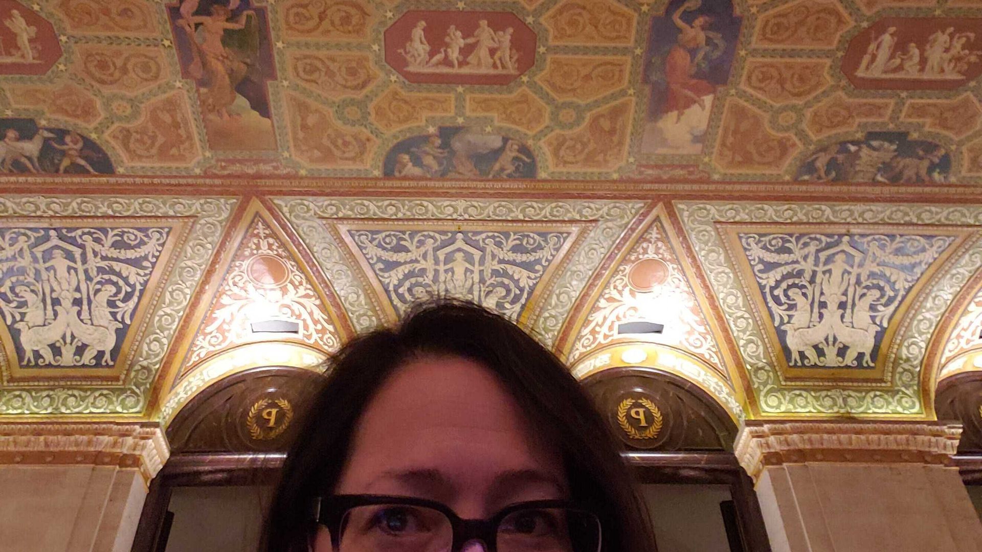 Photo of a woman standing in front of art.