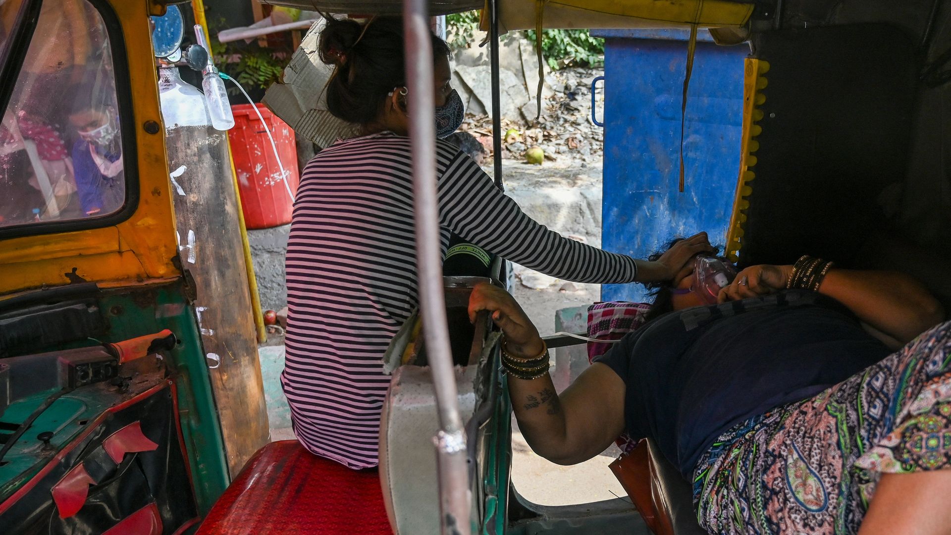 A Covid-19 coronavirus patient, laying on a riscksahw, breathes with the help of oxygen provided by a Gurdwara, a place of worship for Sikhs, along the roadside in Ghaziabad on April 28