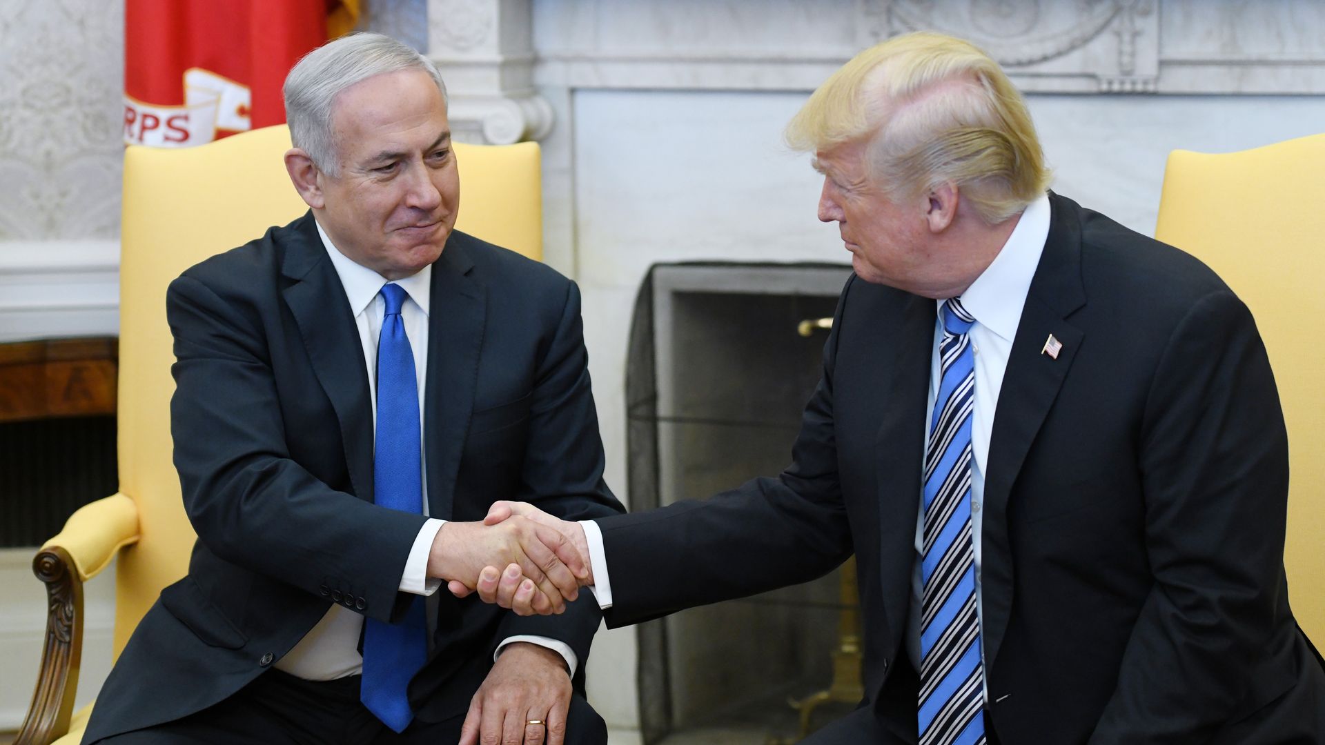 Trump and the Israeli prime minister shake hands in the Oval Office.