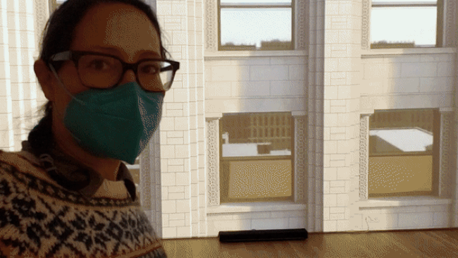 GIF of a woman in front of a building. 