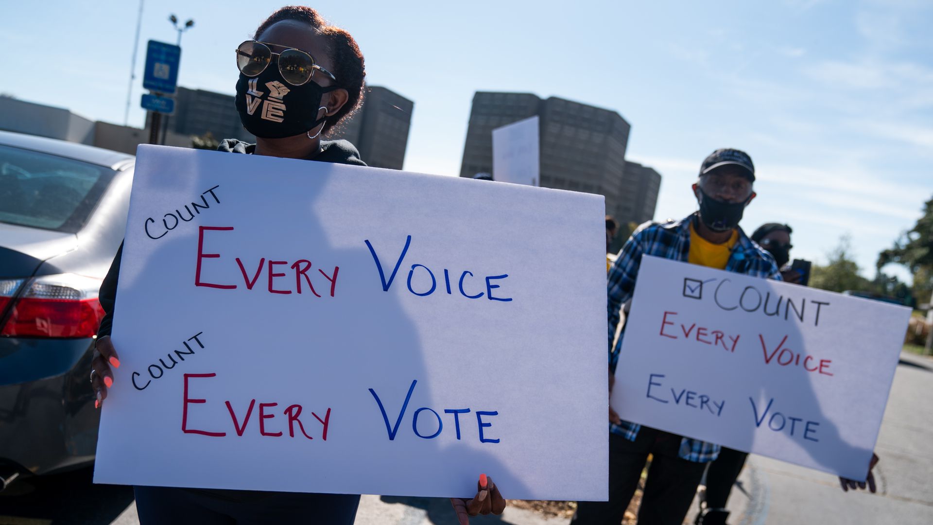 Protesters hold "Count Every Voice, Count Every Vote" signs during the 2020 Presidential election outside the Dekalb County Voter Registration and Elections Office.
