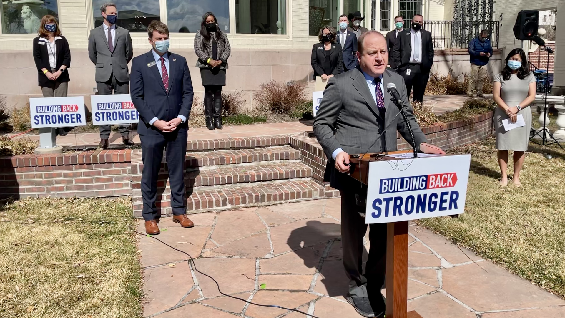 Gov. Jared Polis stands at a podium