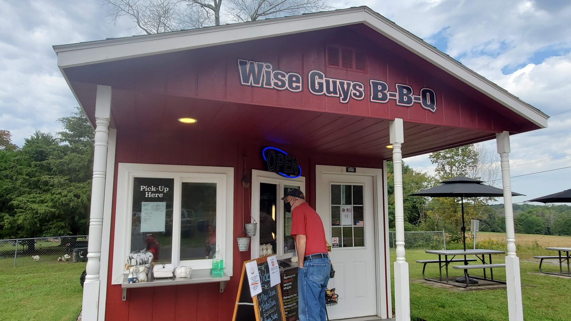 Wise Guys BBQ in Joelton, a small red shack with one man standing at the window to order.