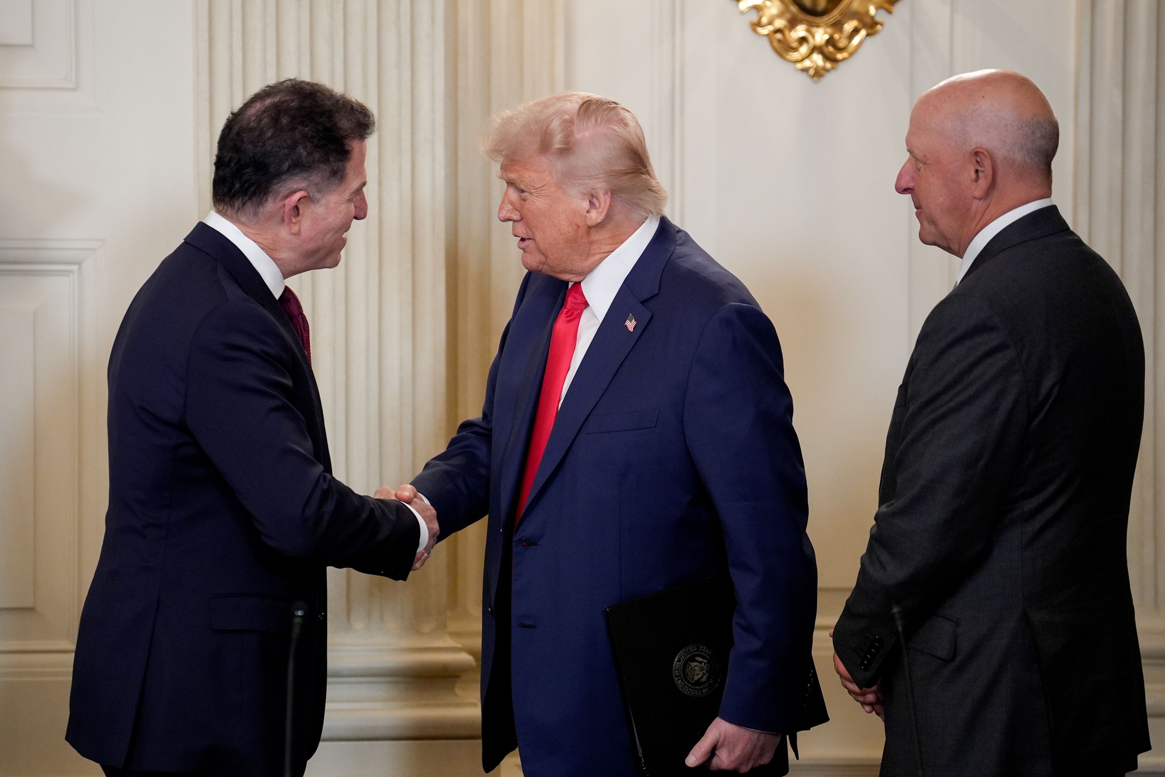 President Trump shakes hands with Dell Technologies founder Michael Dell and Goldman Sachs CEO David Solomon.