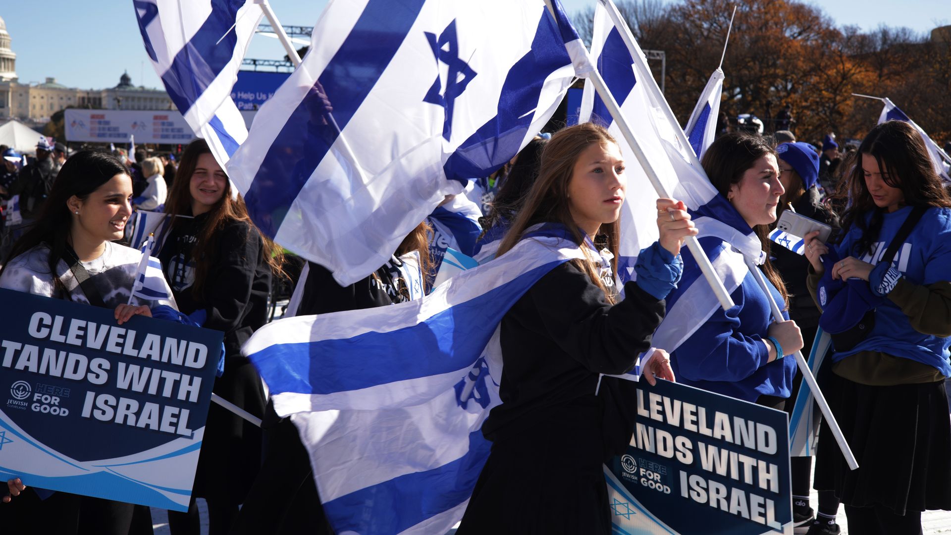 A group of protesters holds "Cleveland stands with Israel" signs and Israel flags
