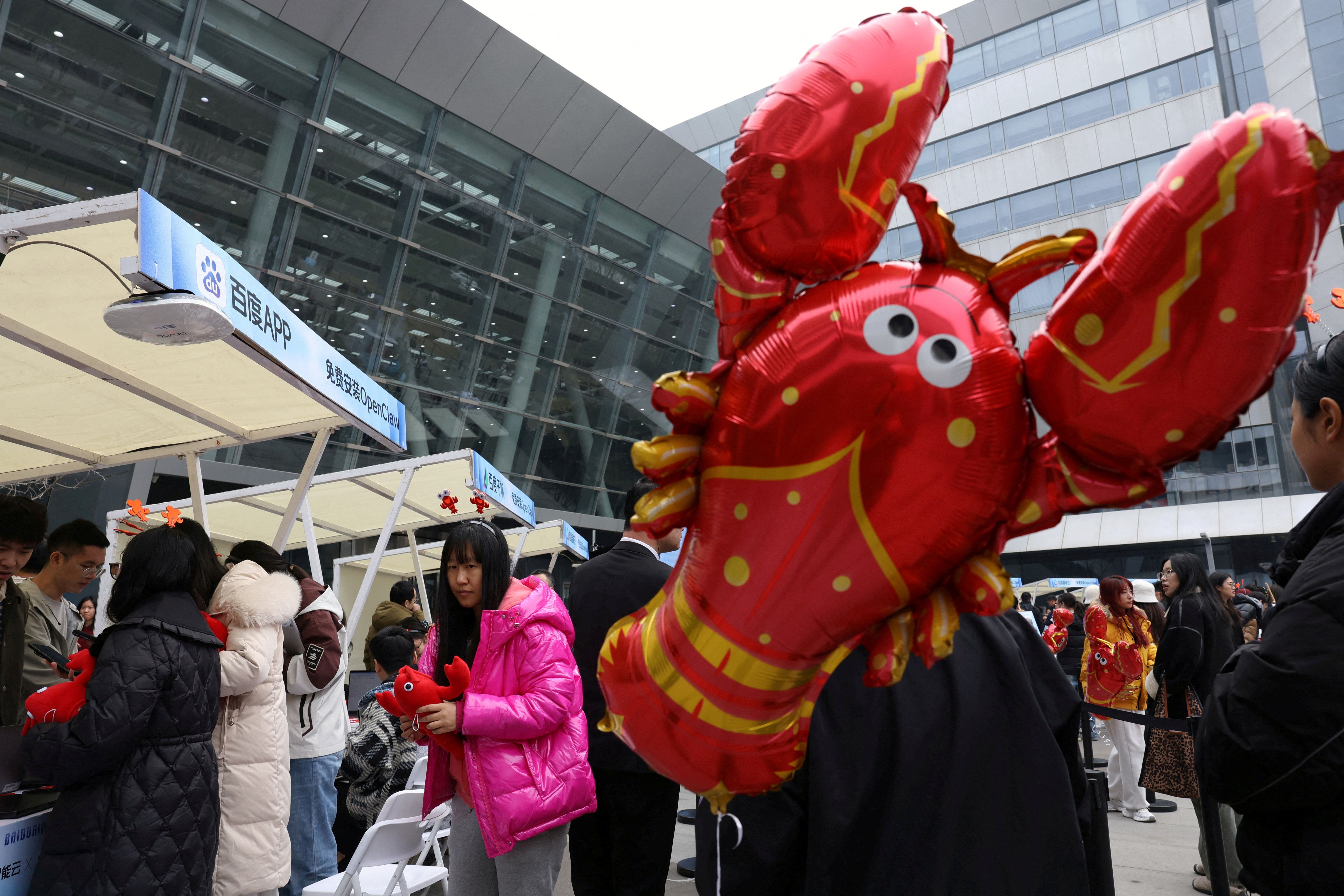 Participants line up near a lobster-shaped balloon to set up and install OpenClaw, an open-source AI agent, outside the Baidu offices in Beijing, China March 17, 2026. REUTERS/Florence Lo 
