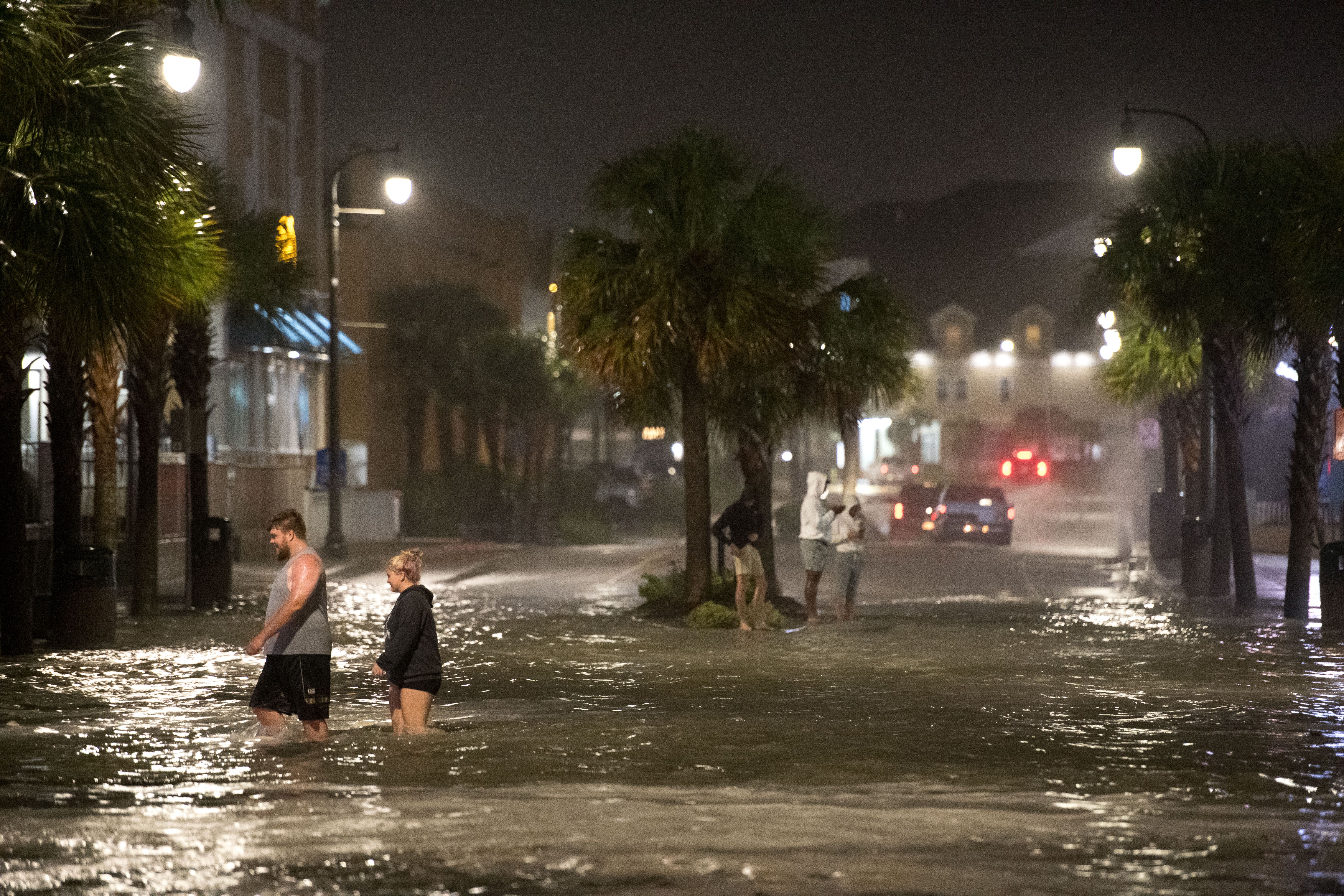  People walk through floodwaters on Ocean Blvd. August 3, 2020 in Myrtle Beach, South Carolina.