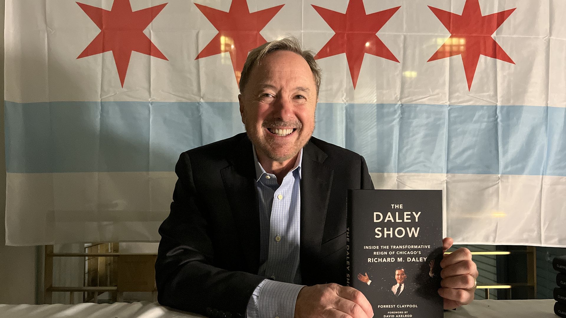 man with a book in front of a chicago flag