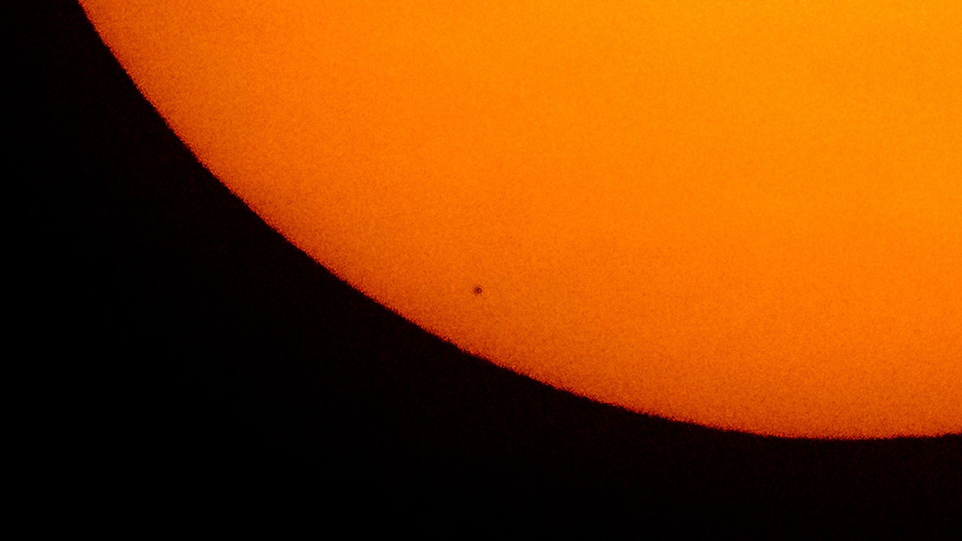 A dark dot on the face of the Sun made by Mercury