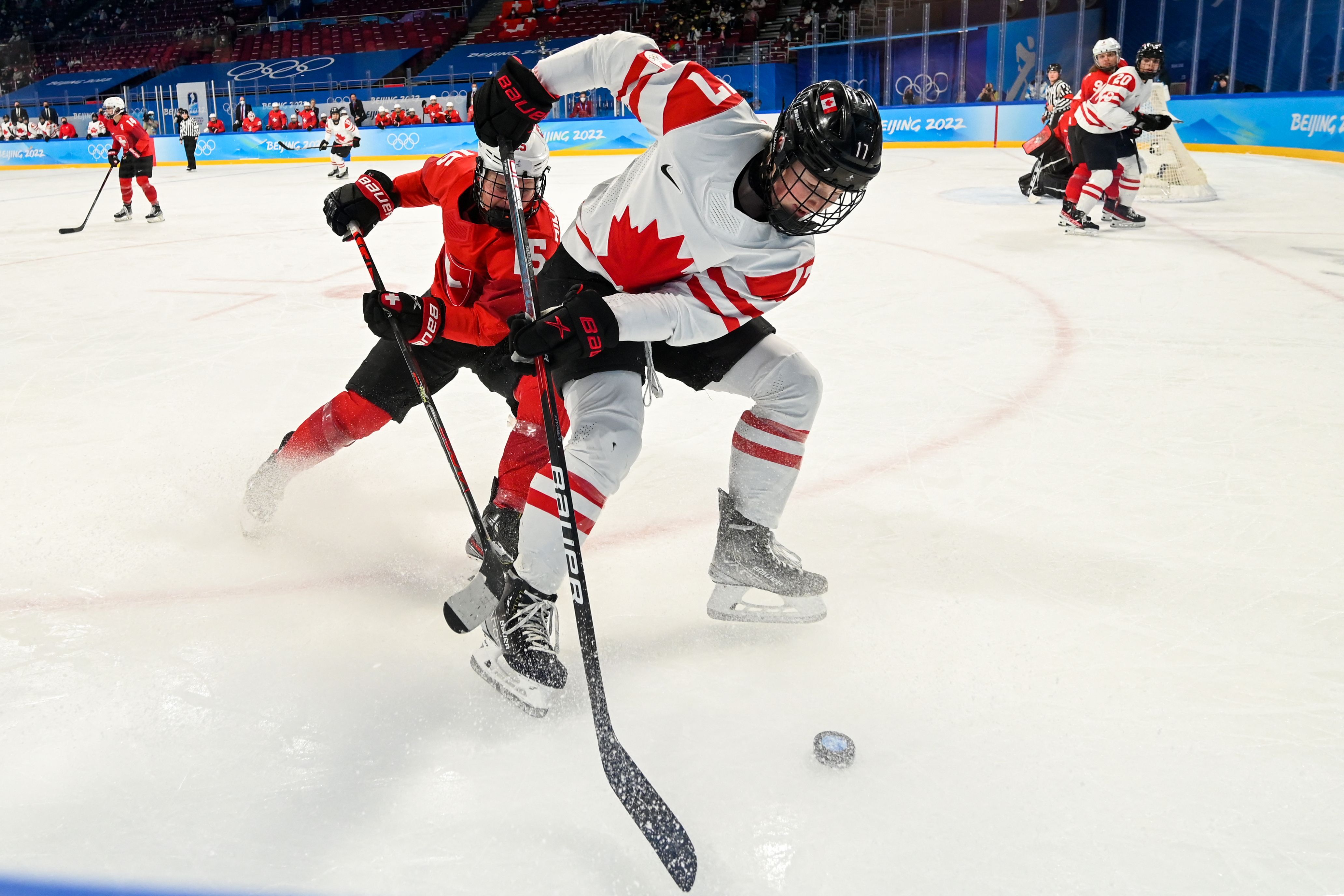 Canada's Ella Shelton (R) and Switzerland's Laura Zimmermann fight for the puck during the women's play-offs semifinal match of the Beijing 2022 Winter Olympic Games ice hockey competition 