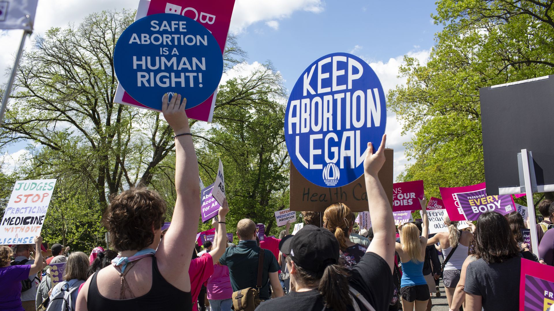 Activists holding abortion rights signs and shout slogans while joining in a rally
