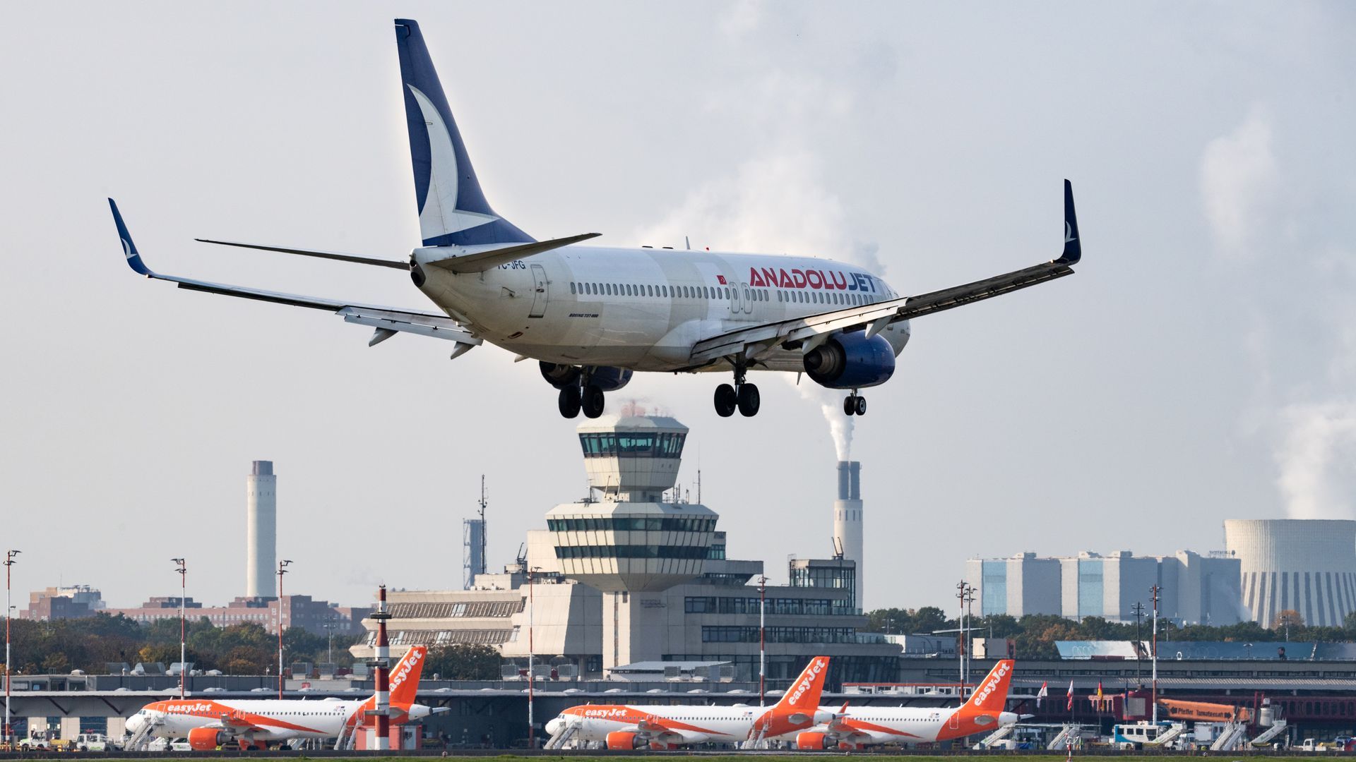 A passenger jet lands at Berlin Tegel Airport.