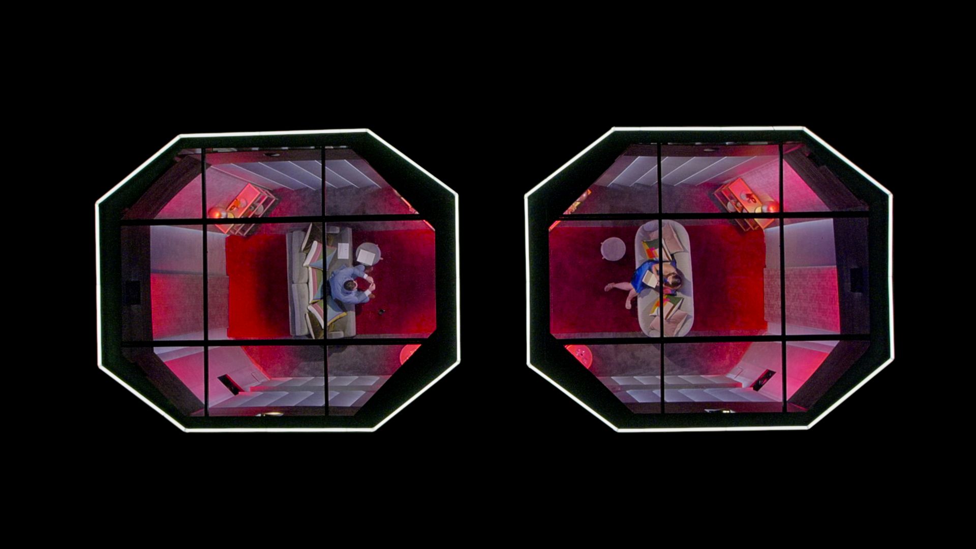 An aerial view of two isolation pods with a person sitting inside them