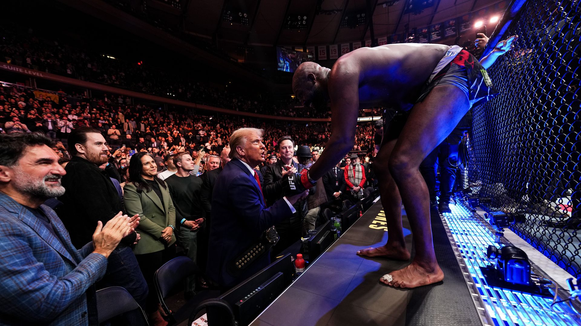 Donald Trump shakes hands with a UFC fighter in a packed arena fight