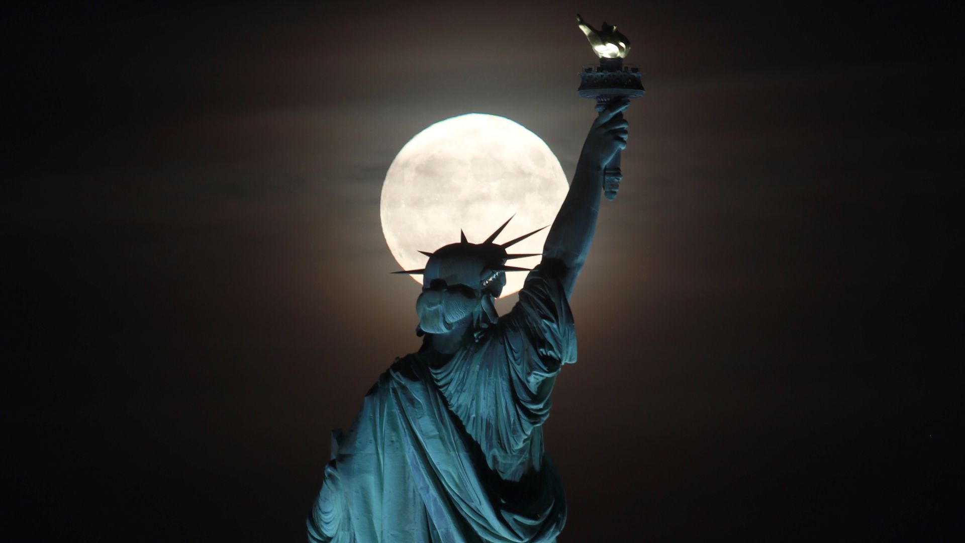  The full Harvest Moon rises behind the Statue of Liberty in New York City on September 13, 2019 as seen from Jersey City, New Jersey. 